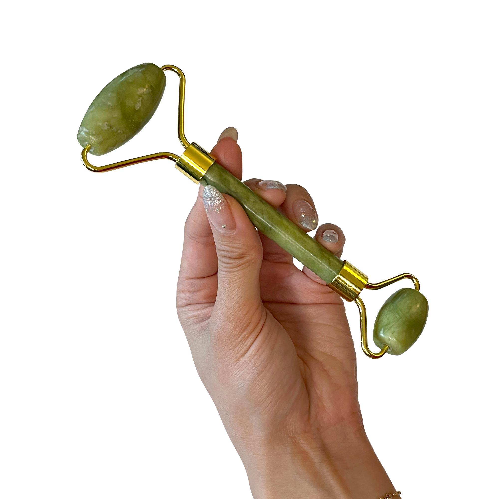 A hand holds a green jade roller with gold-colored metal accents.