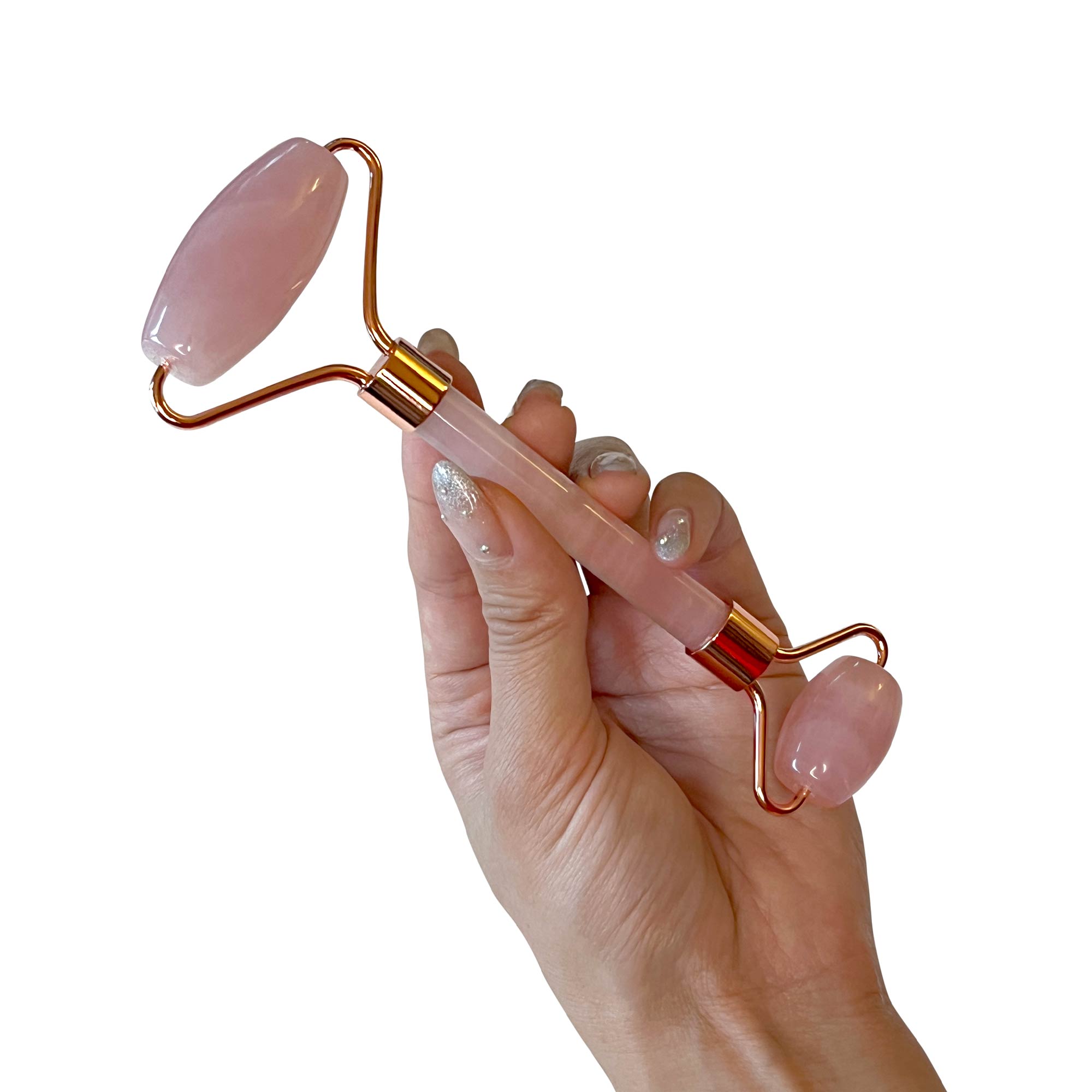 A hand holds a rose quartz facial roller with a large and small stone.