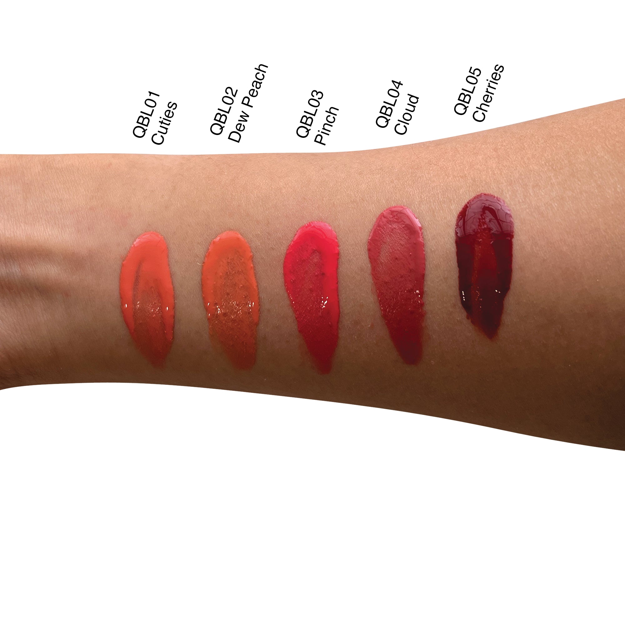 Five swatches of liquid blush in varying shades of orange, pink, and red on an arm.