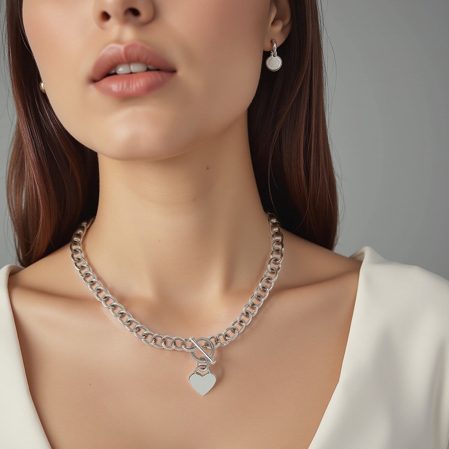 Sterling silver rolo chain necklace with a heart toggle charm and rhodium plating.
