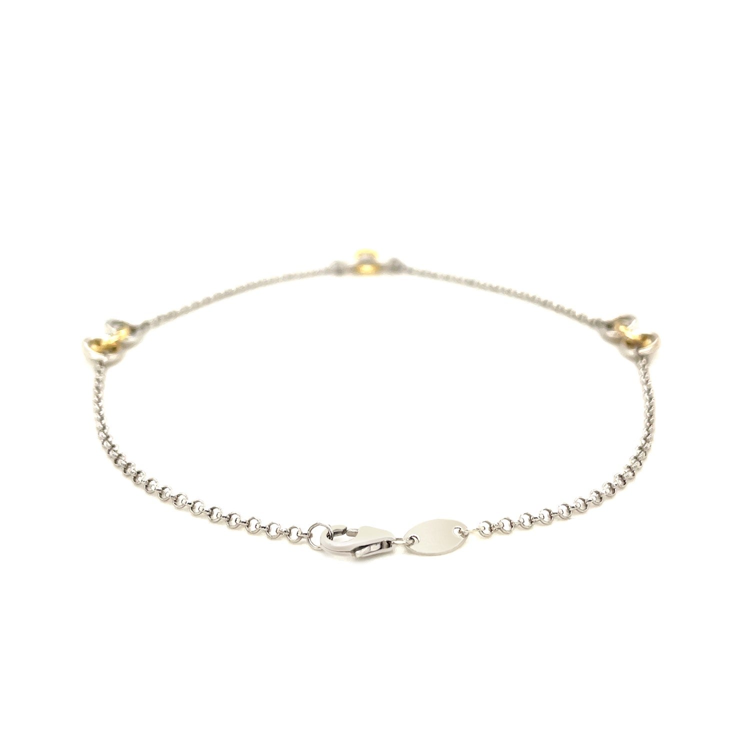 A sterling silver rolo chain anklet with three yellow gold triple ring stations.