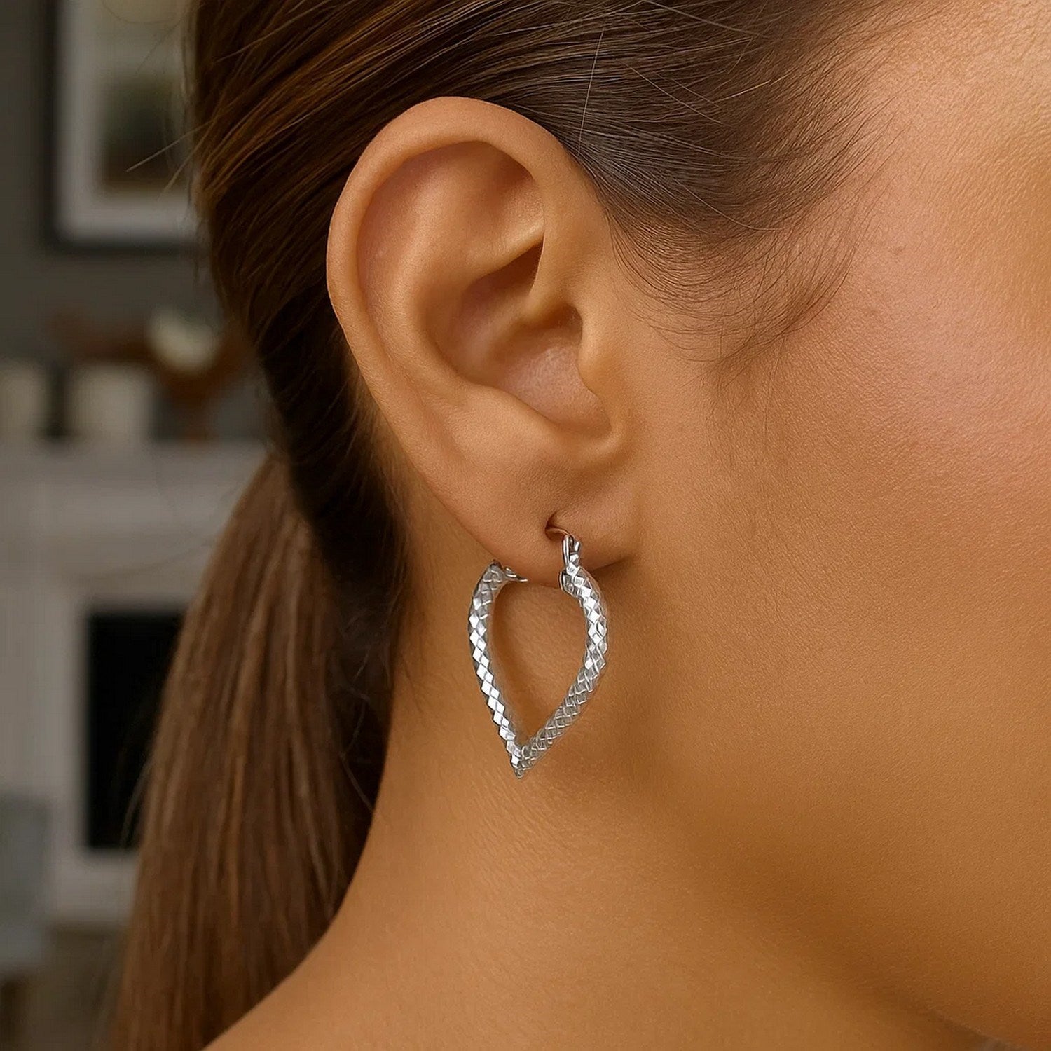 Sterling silver rhodium plated heart-shaped hoop earrings with a diamond-cut finish.