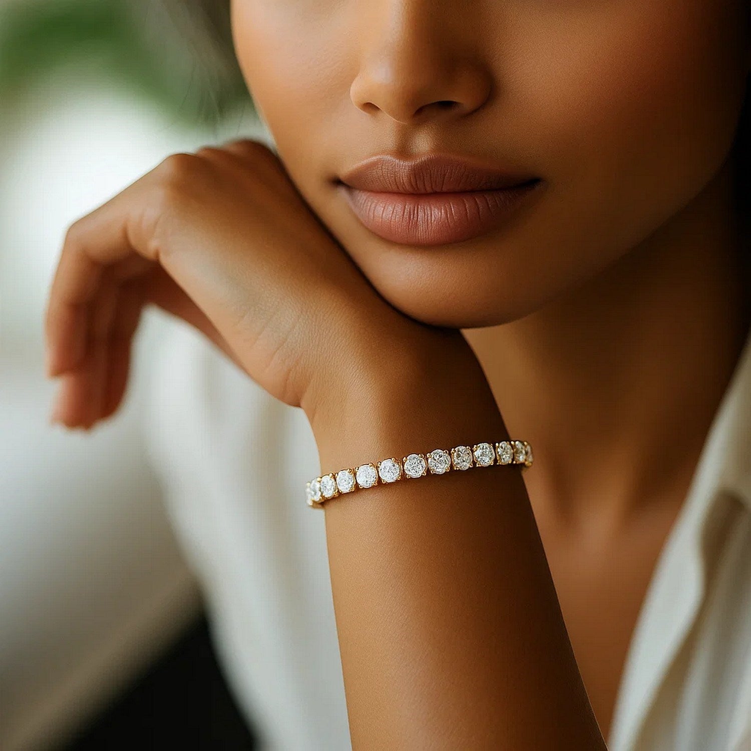 A woman wears a yellow gold tennis bracelet with round lab-grown diamonds.