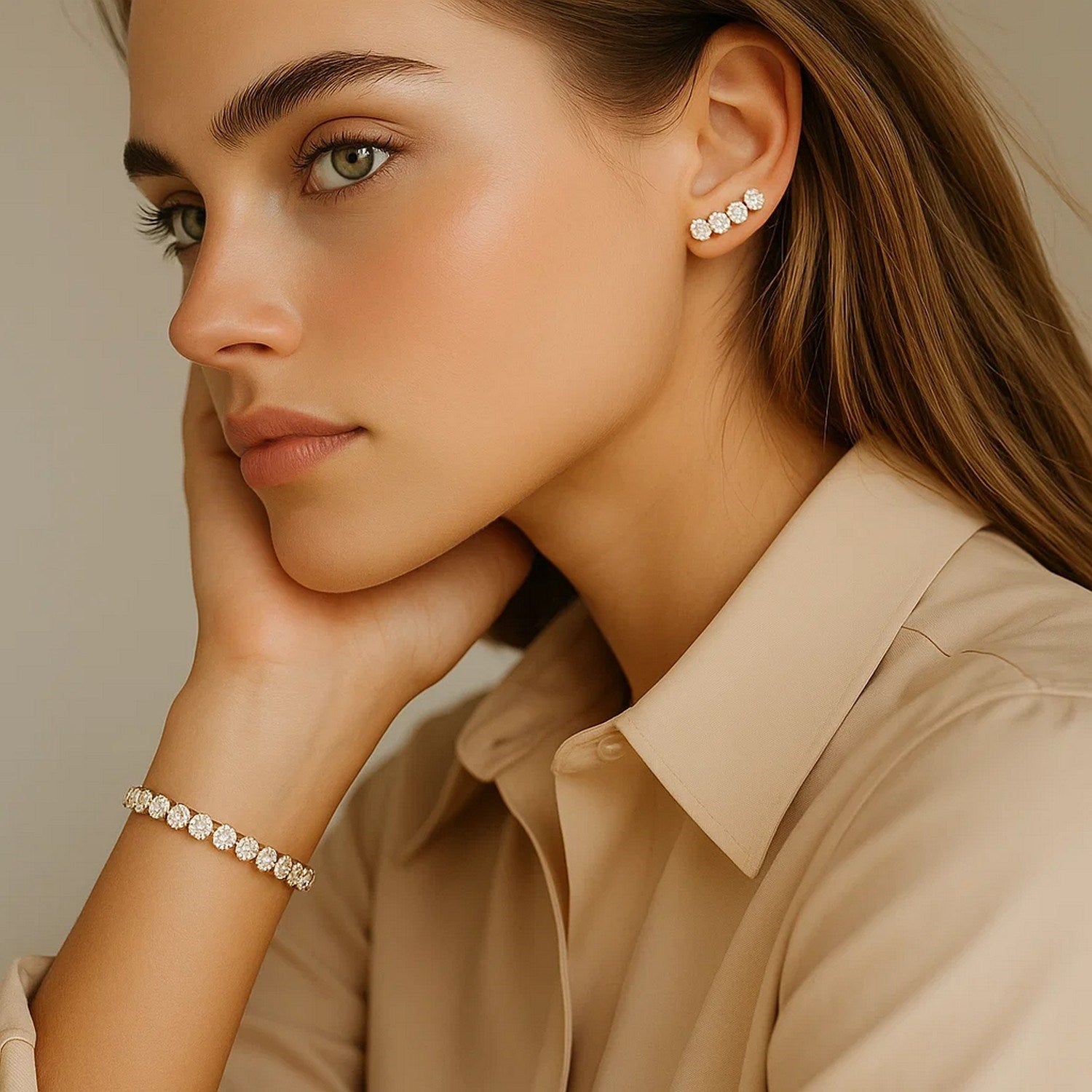 A woman wears a yellow gold tennis bracelet with round diamonds.