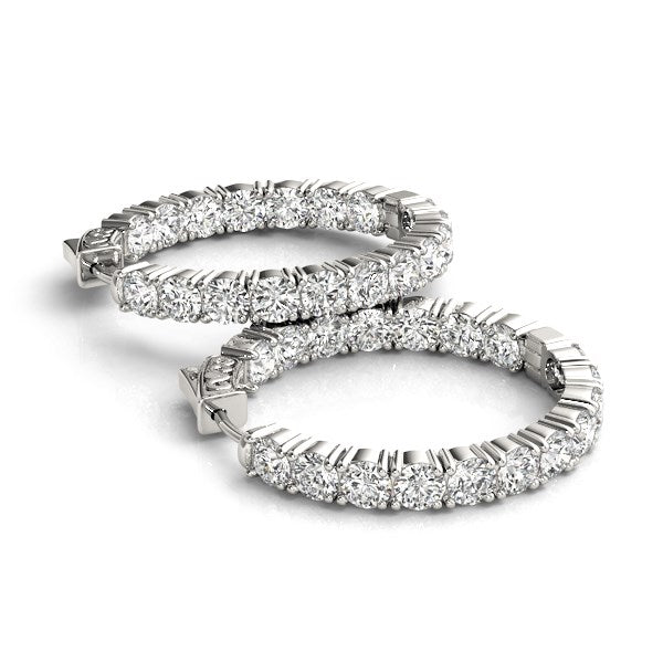 Two 14k white gold hoop earrings with prong-set round diamonds on both sides.