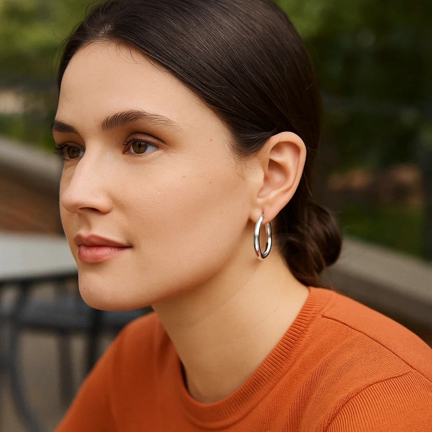 Sterling silver rhodium plated thick style polished hoop earrings on a woman.
