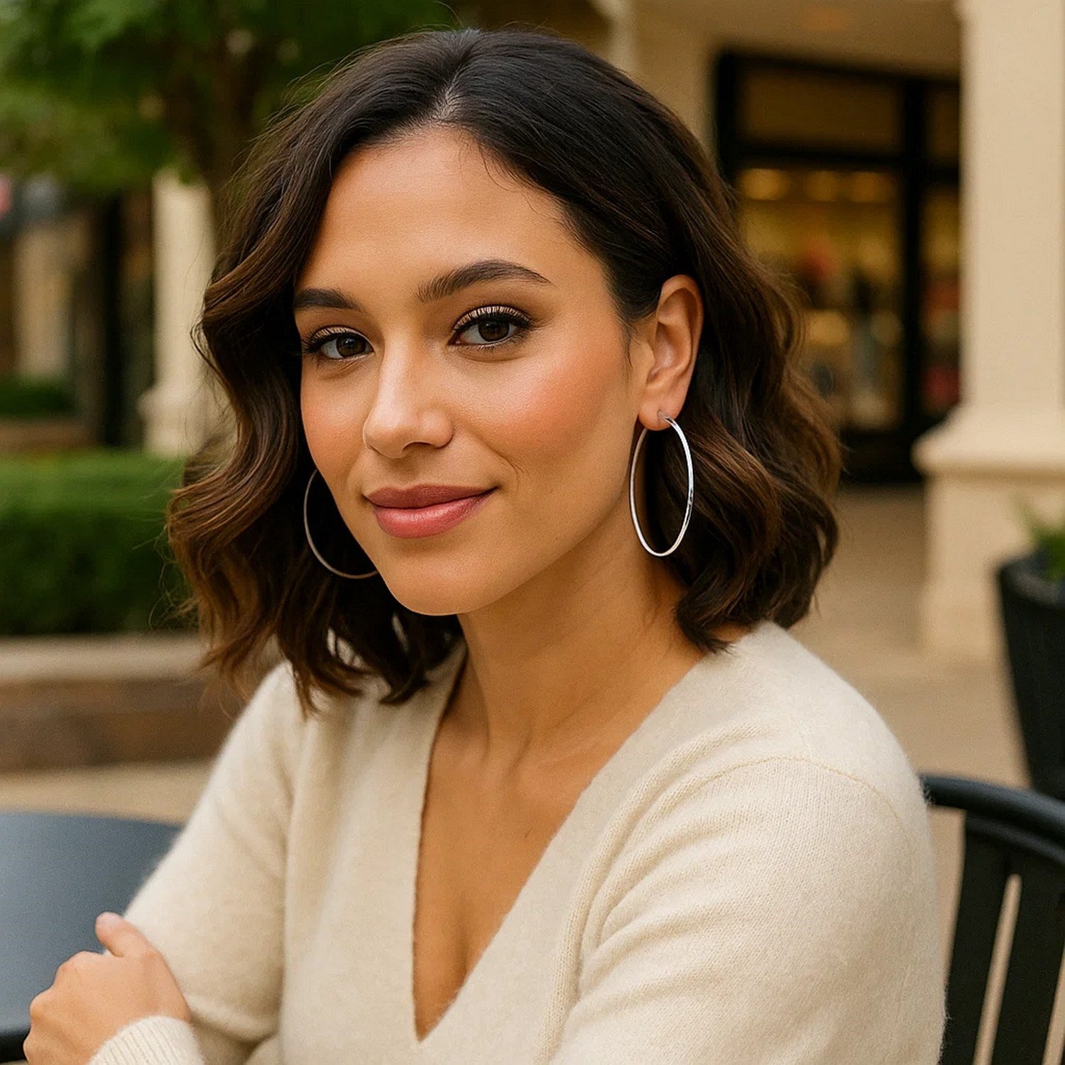 Sterling silver large polished round hoop earrings on a woman.
