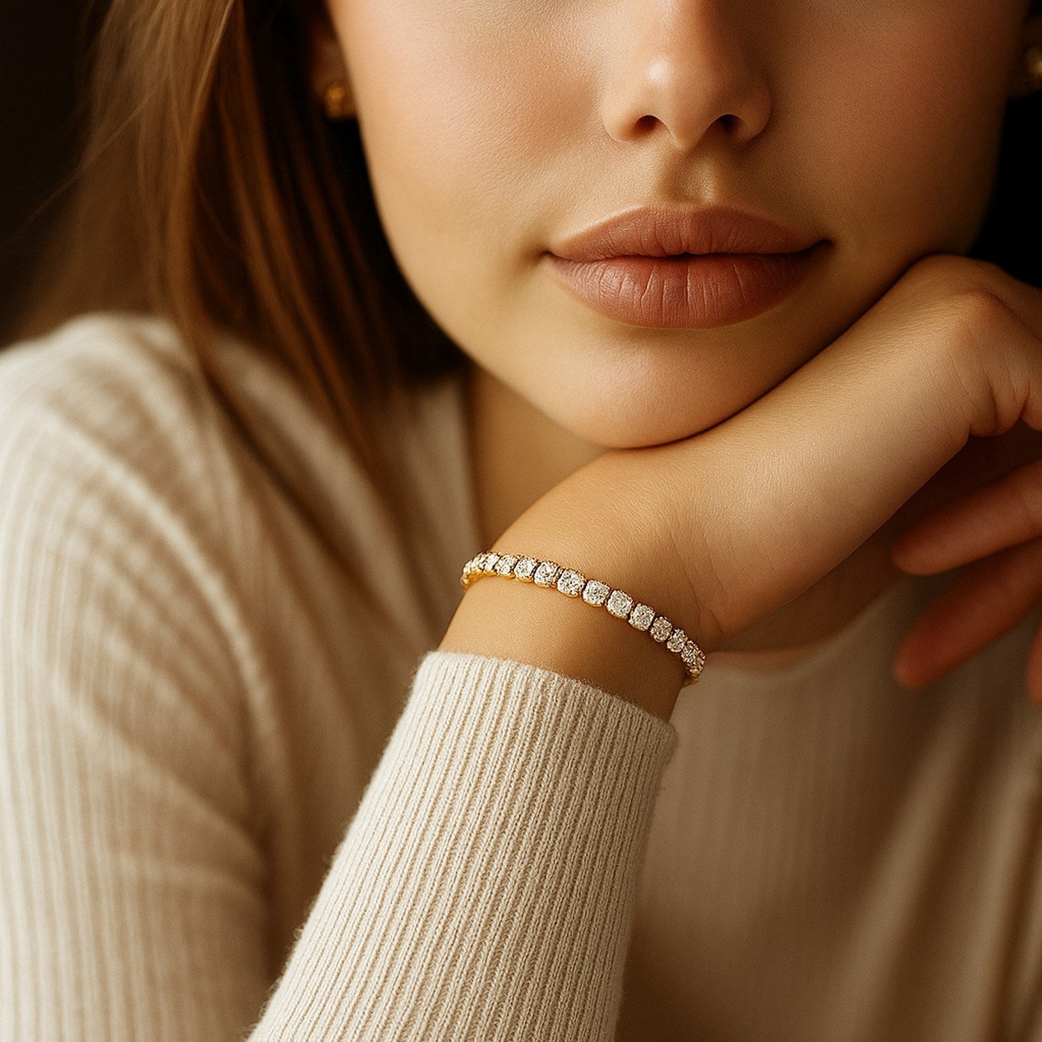 A woman wears a yellow gold lab grown diamond tennis bracelet on her left wrist.