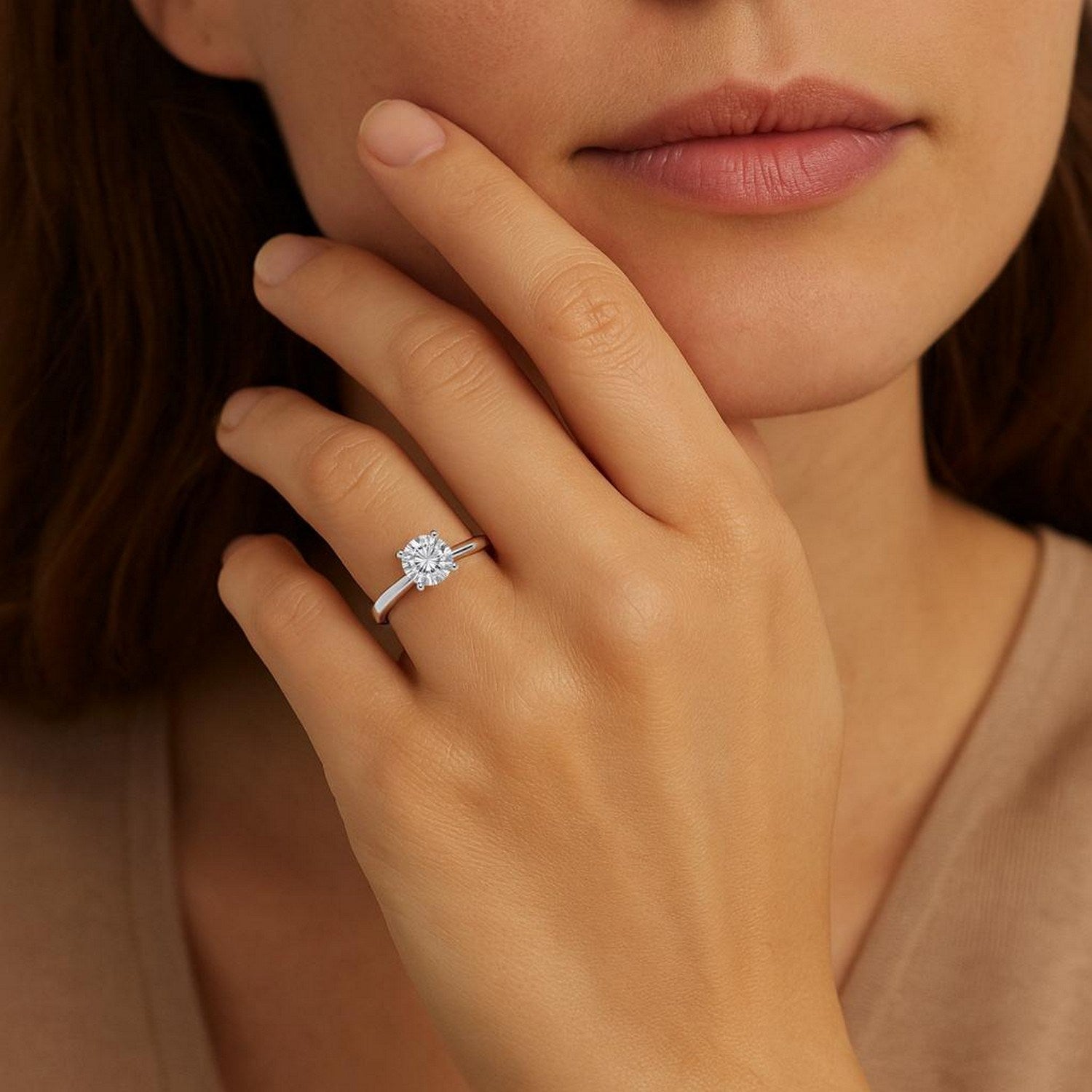 A woman wears a 1 carat round lab grown diamond solitaire ring in 14K white gold.