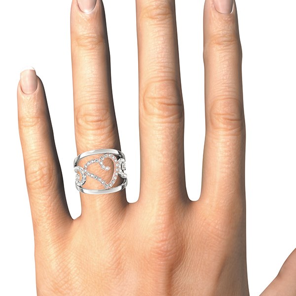 A white gold ring with a diamond-encrusted heart and filigree design on a hand.