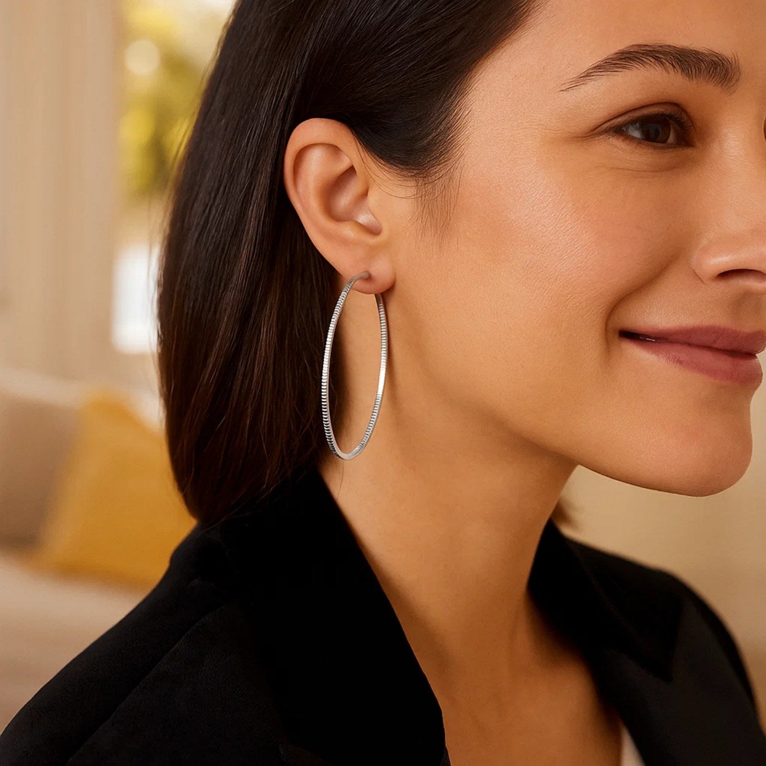 Ridge textured hoop earrings in sterling silver on a woman.