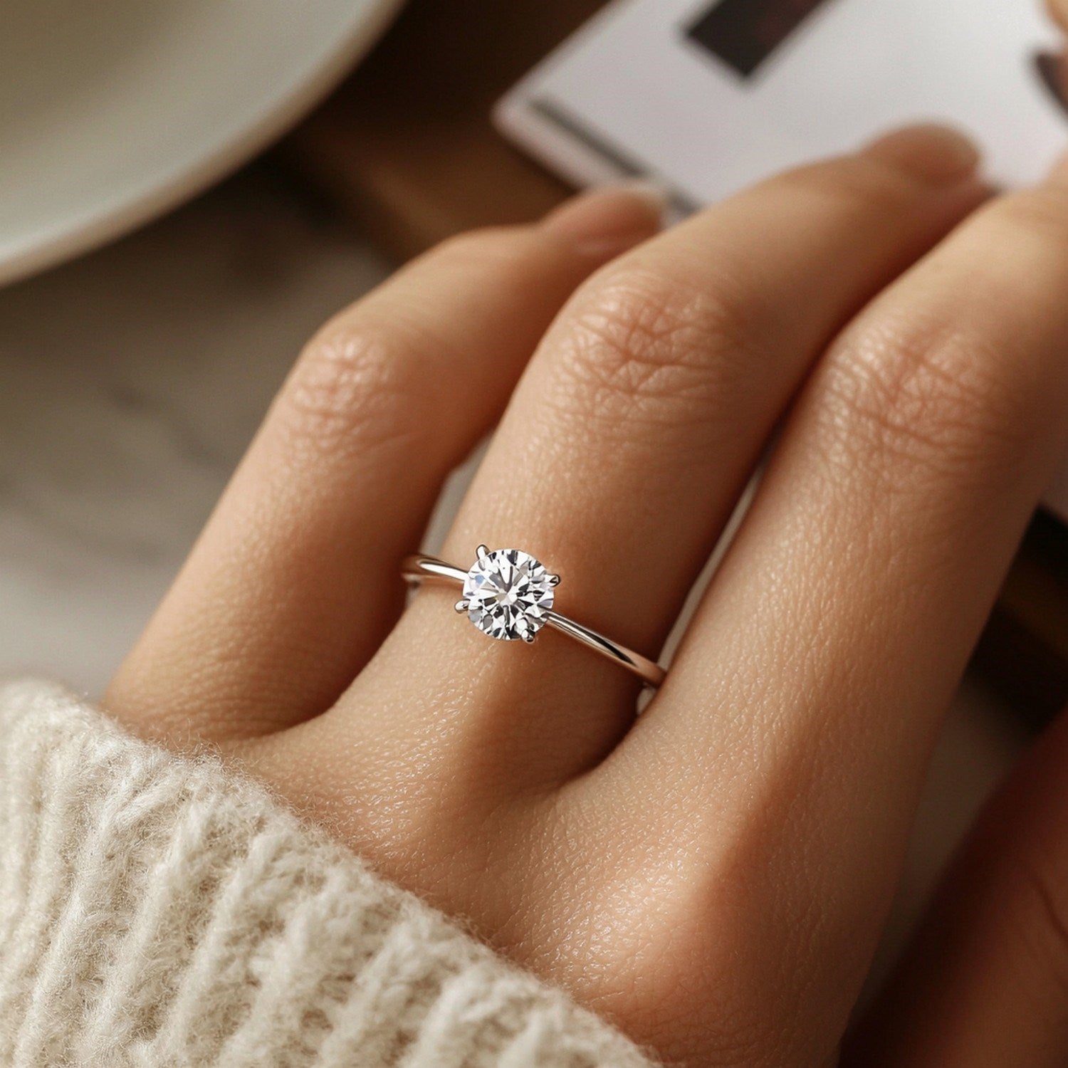 A hand wears a 1 1/2 carat round lab grown diamond ring in 10K white gold.
