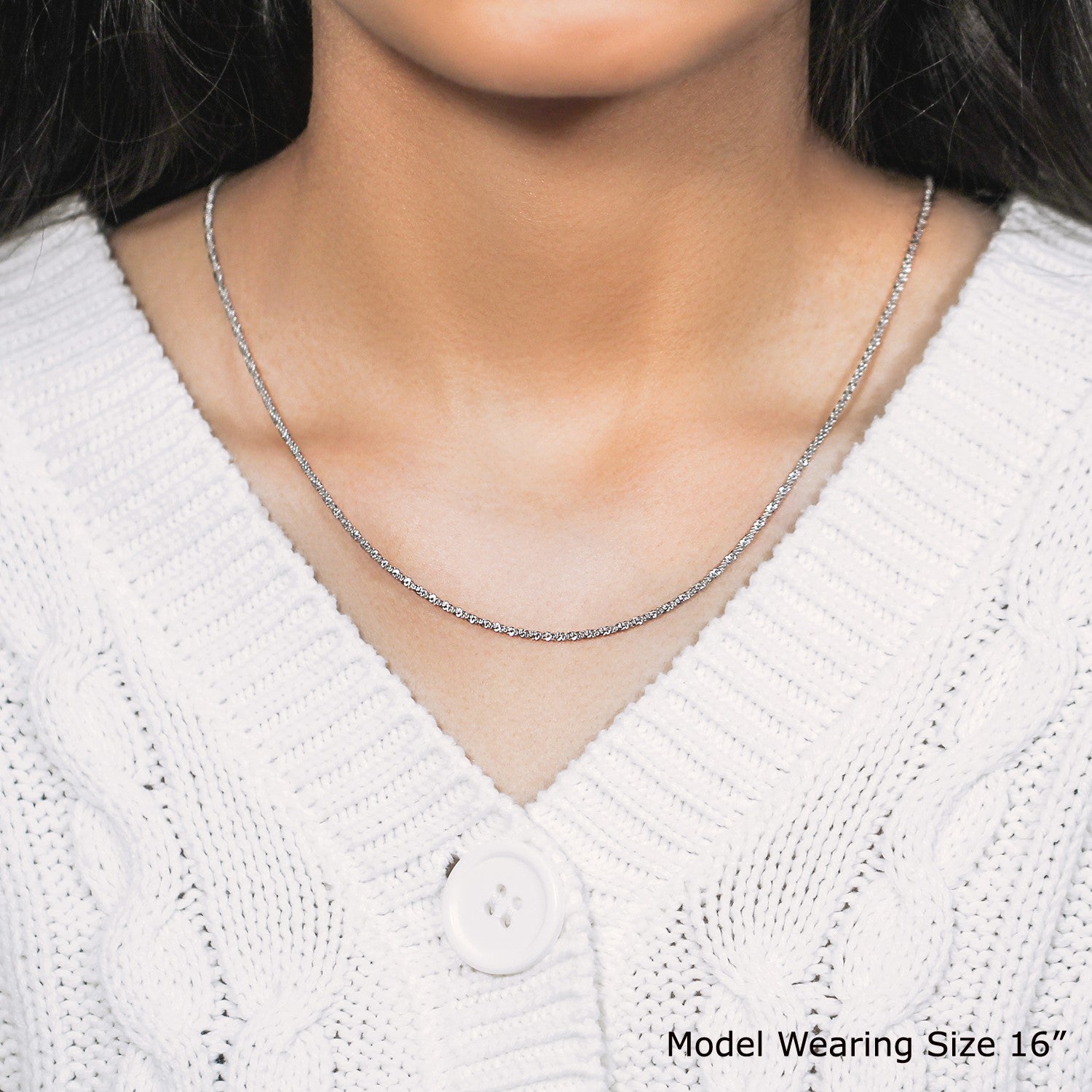 Sterling silver 1.5mm adjustable sparkle chain on a model wearing a white sweater.