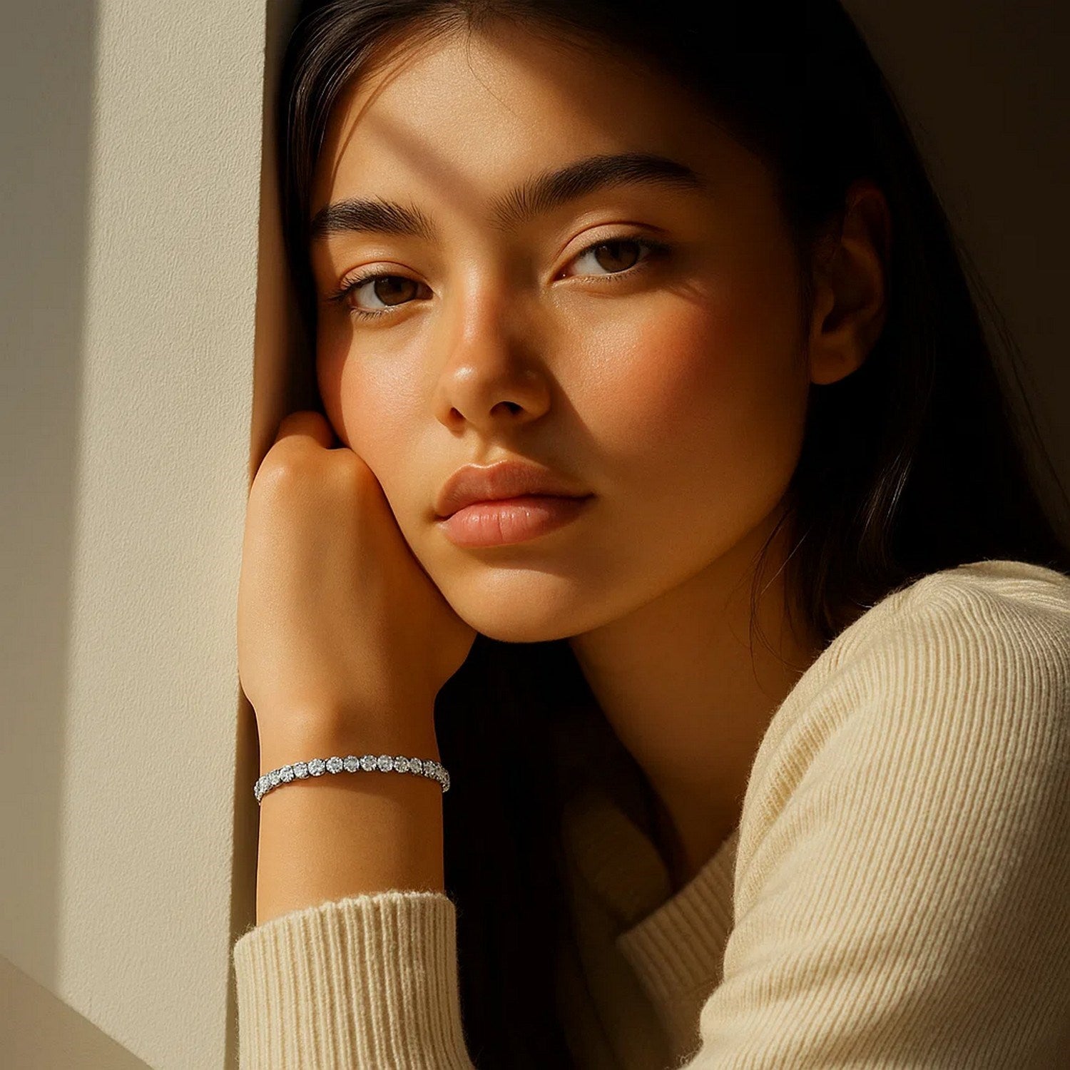A woman wears a lab grown round diamond tennis bracelet in 14k white gold.