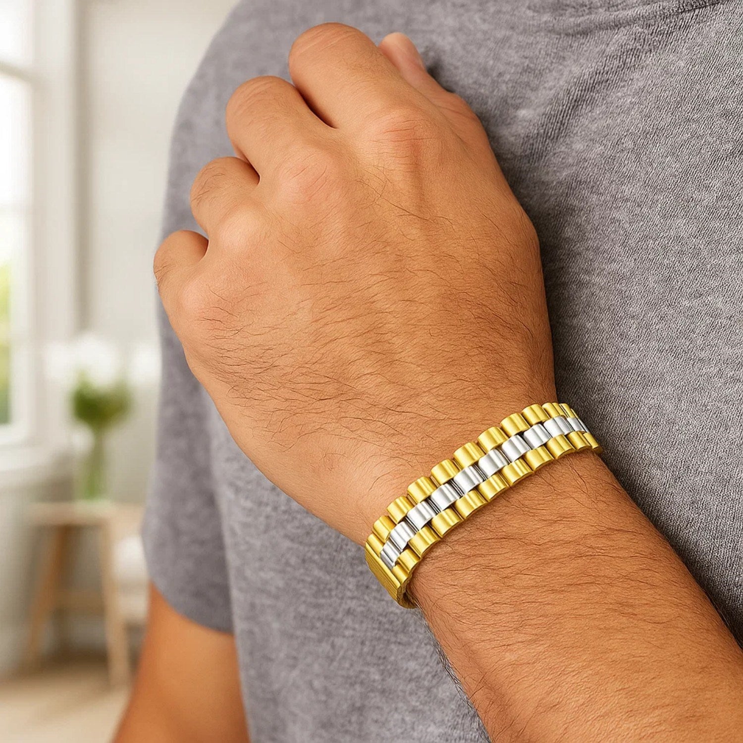 A man wears a two-tone gold panther link bracelet on his wrist.
