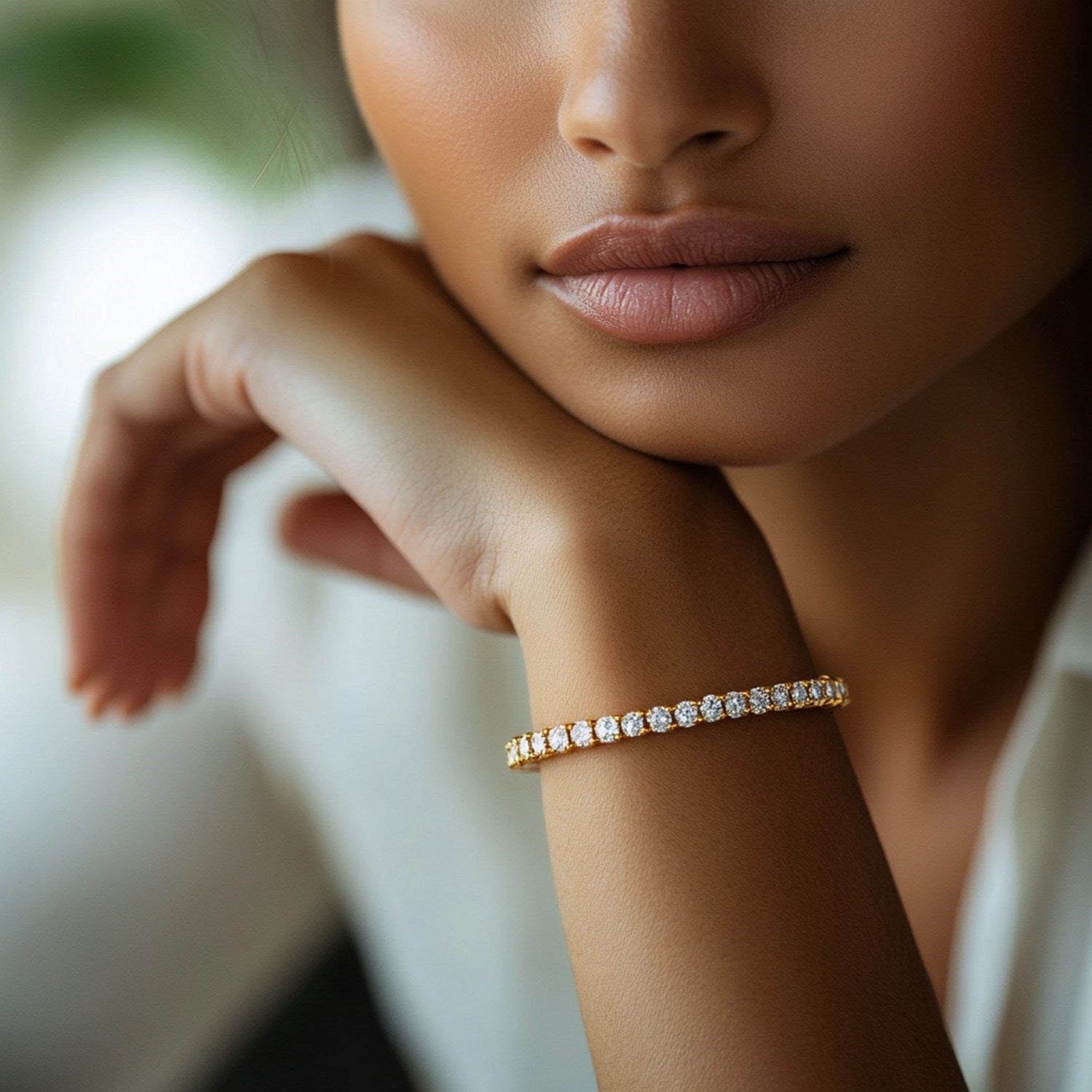 Lab grown round diamond tennis bracelet in 14k yellow gold on a woman's wrist.