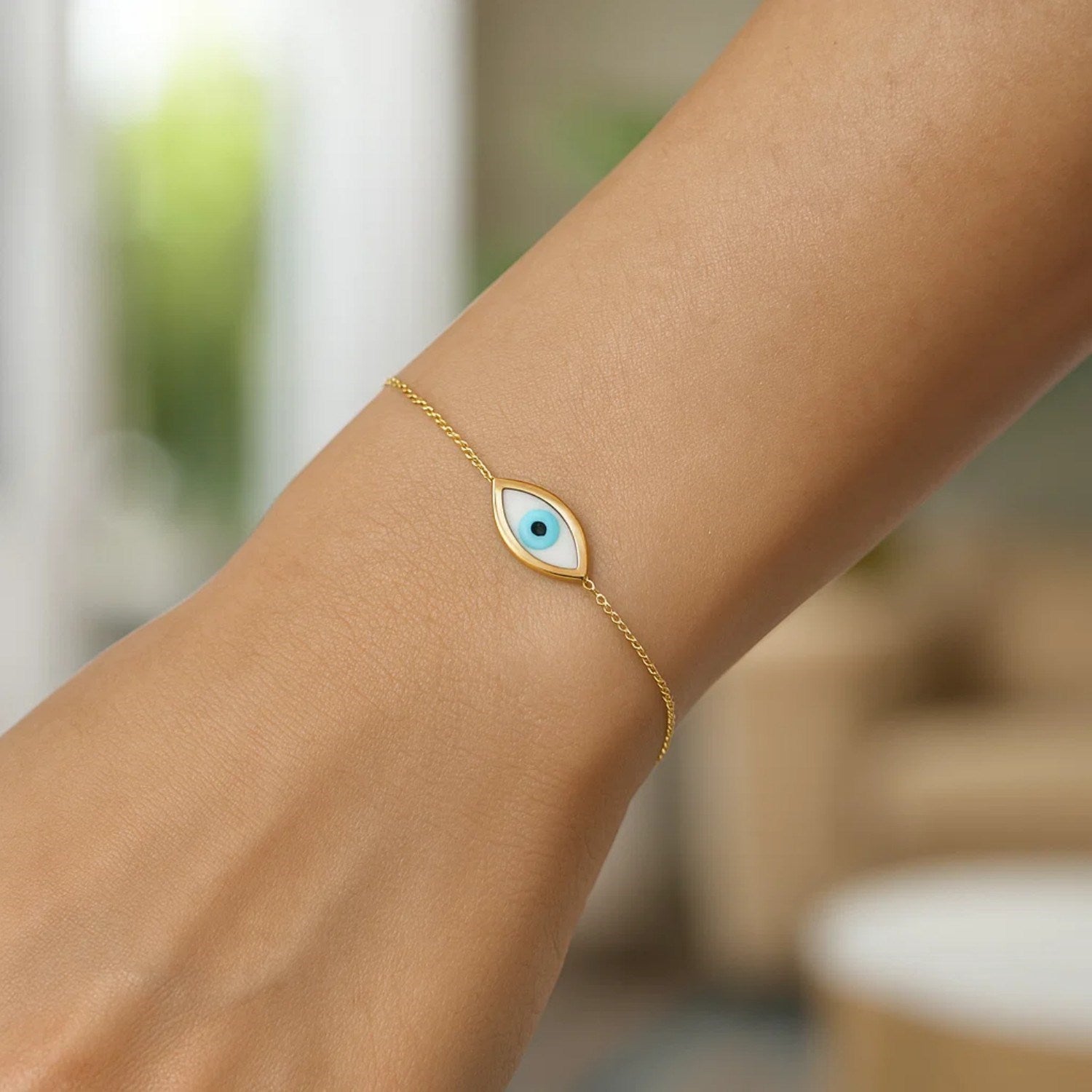 14k yellow gold Mother Of Pearl Evil Eye bracelet on a wrist.