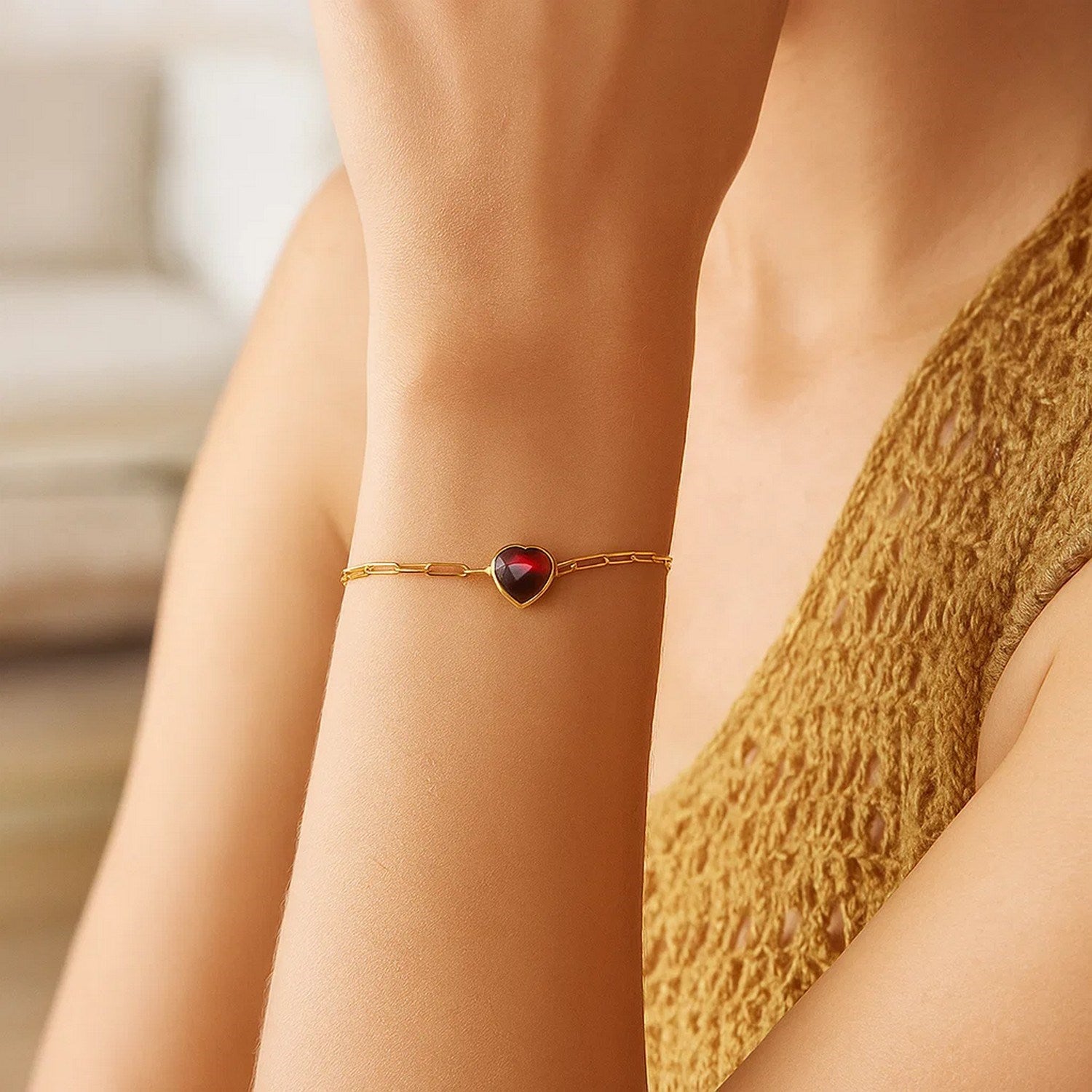 14K yellow gold link bracelet with a heart-shaped garnet gemstone.