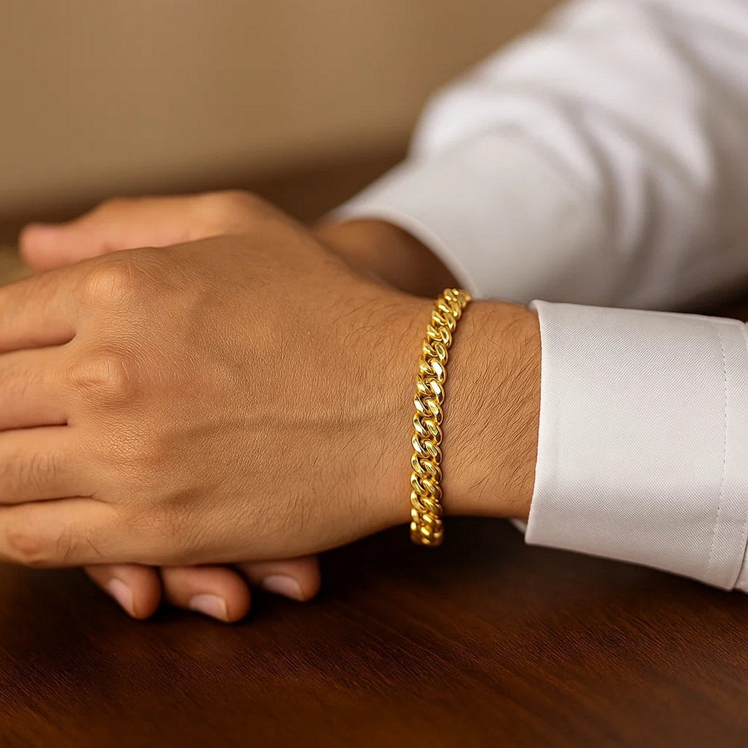 14k yellow gold classic Miami Cuban solid bracelet on a person's wrist.