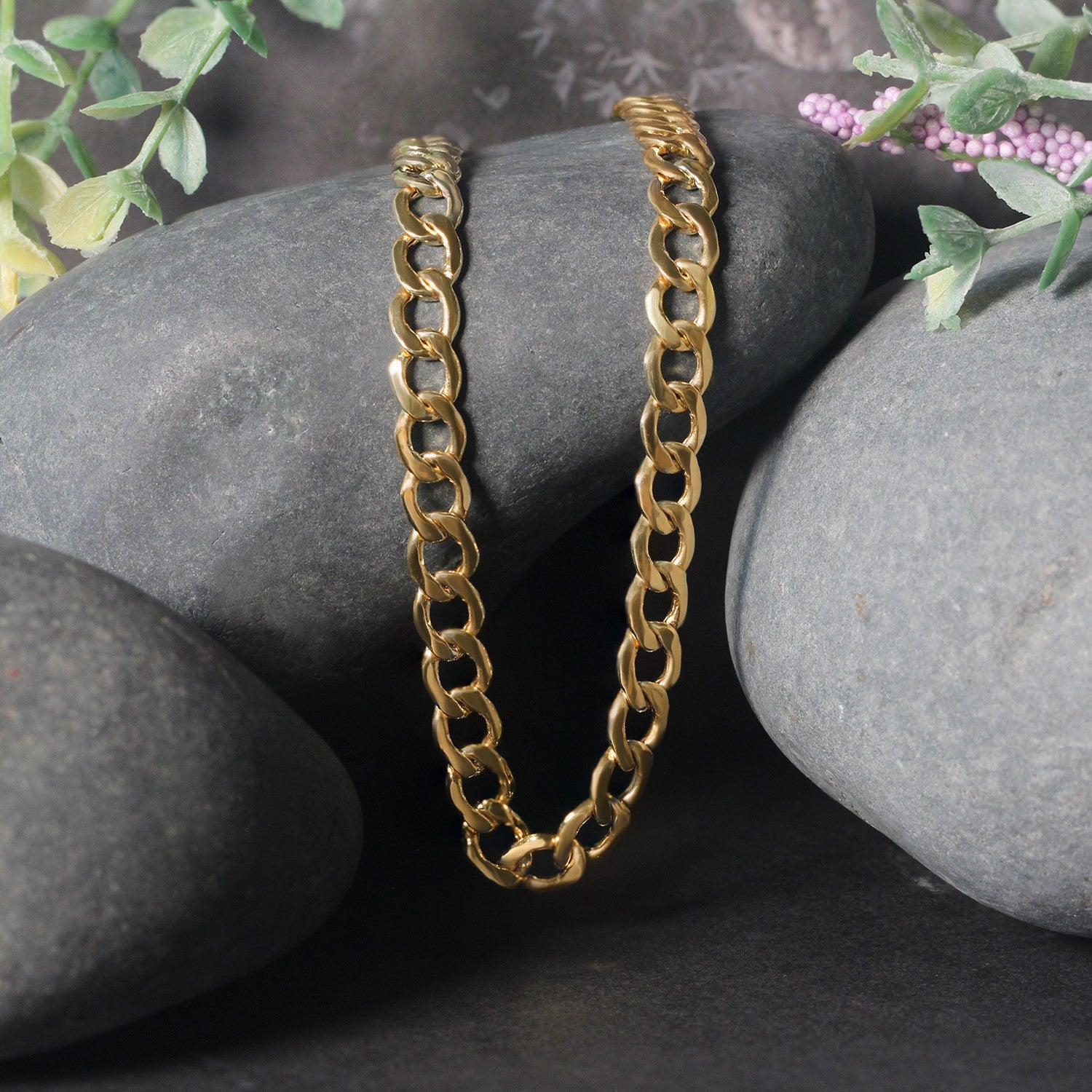 10k yellow gold curb chain with a lobster clasp, displayed on dark grey stones.