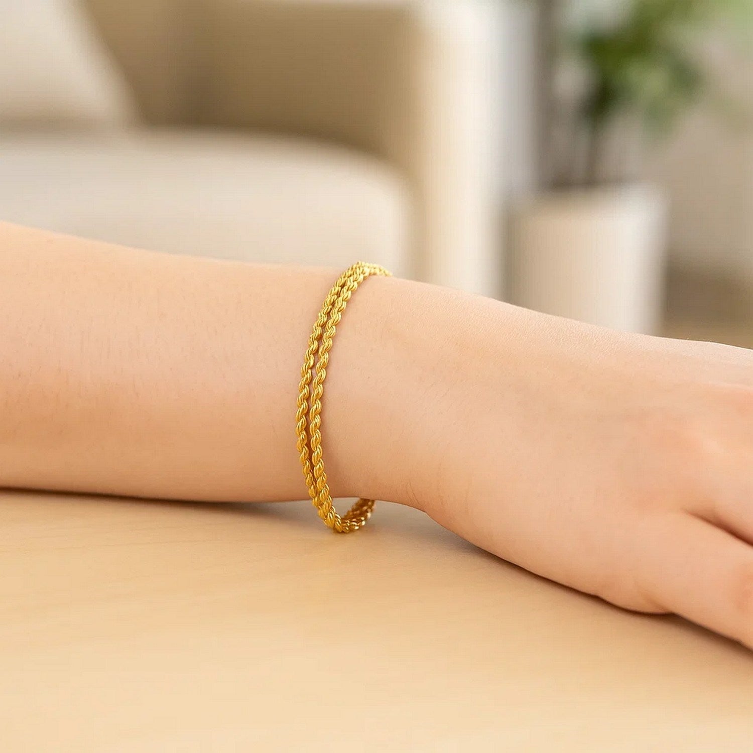 Double rope chain bracelet in 10k yellow gold on a person's wrist.