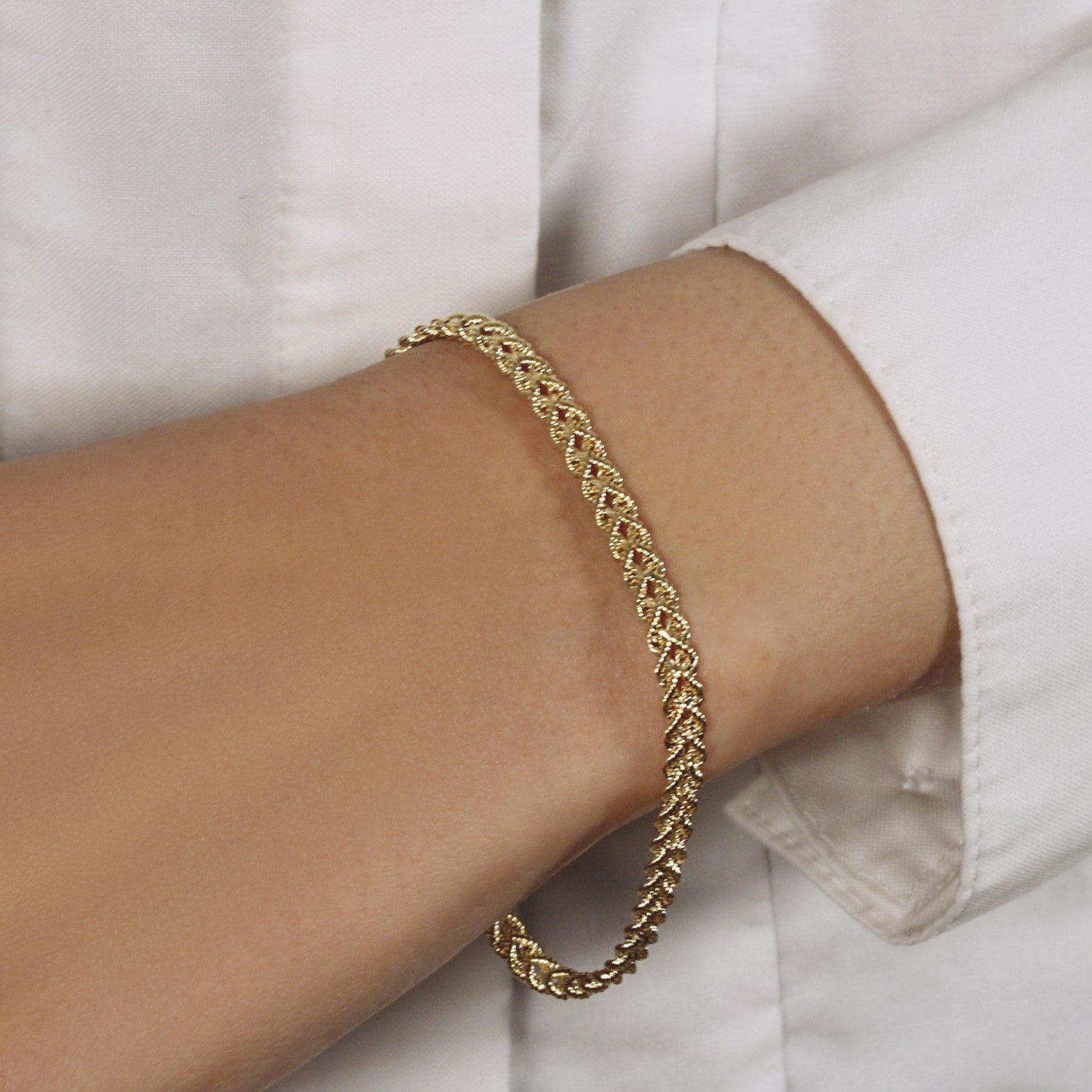 Double rope chain bracelet in 10k yellow gold on a person's wrist.