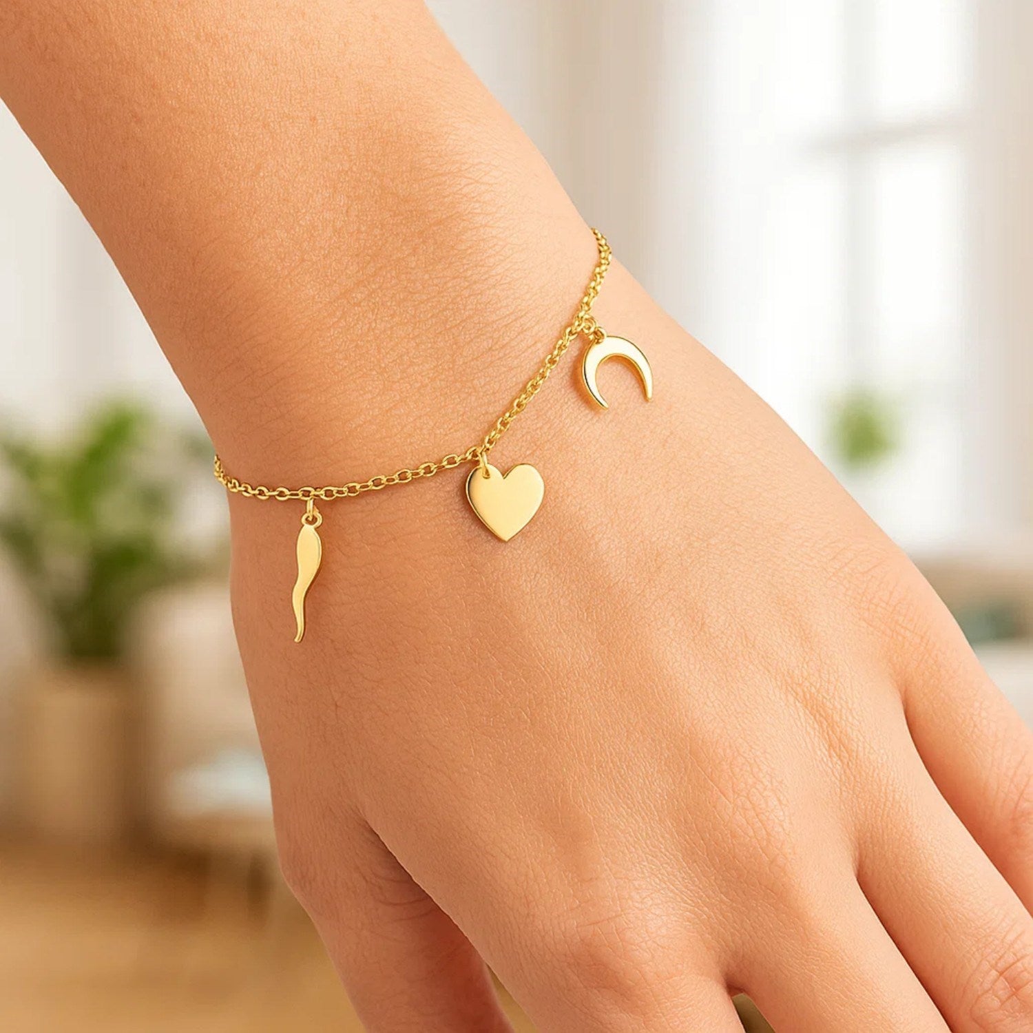 14k yellow gold bracelet with a heart, crescent moon, and horn charm.