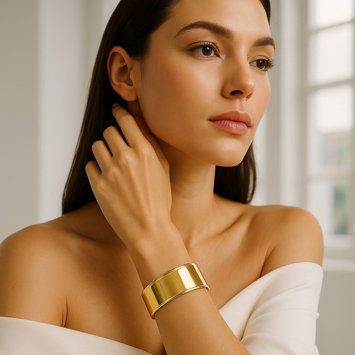 14K yellow gold classic cuff bangle on a woman's wrist.