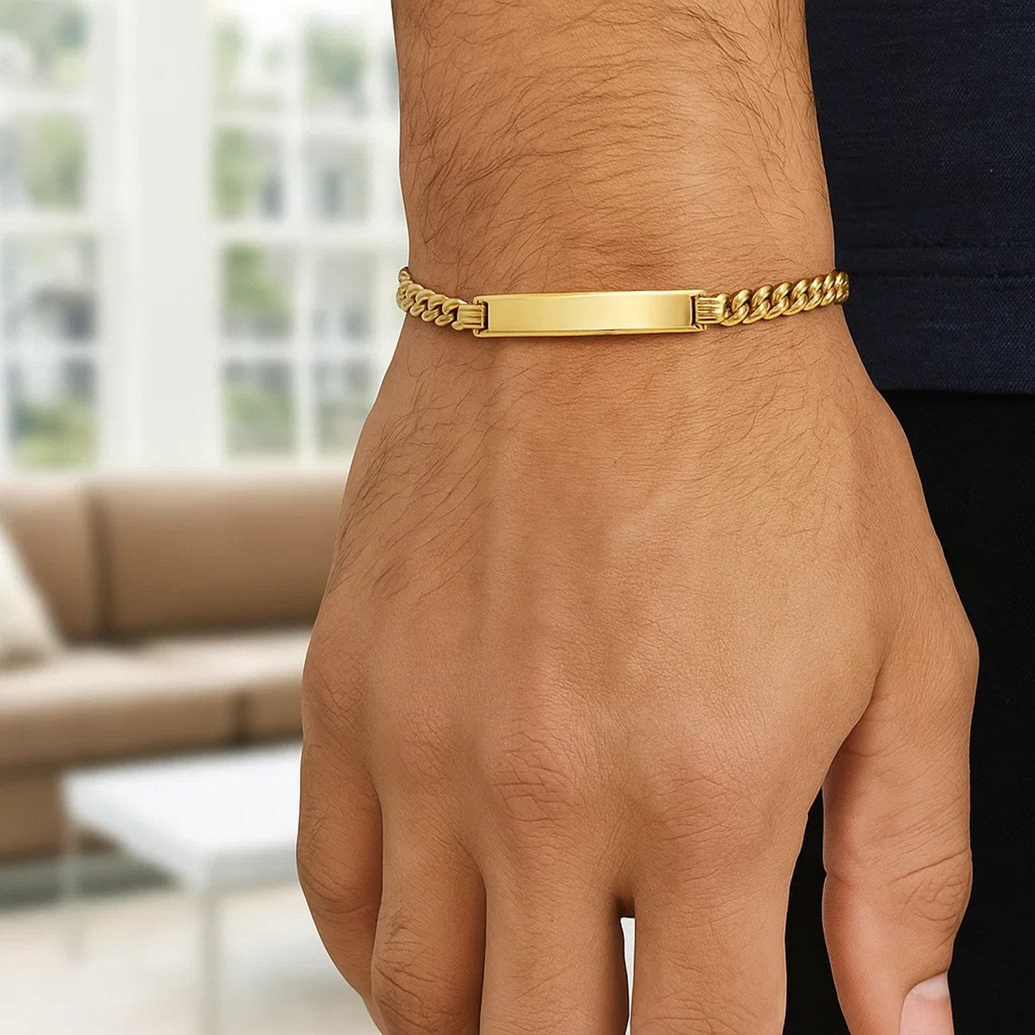 14K yellow gold lite Cuban ID bracelet with a polished rectangular plate on a man's wrist.