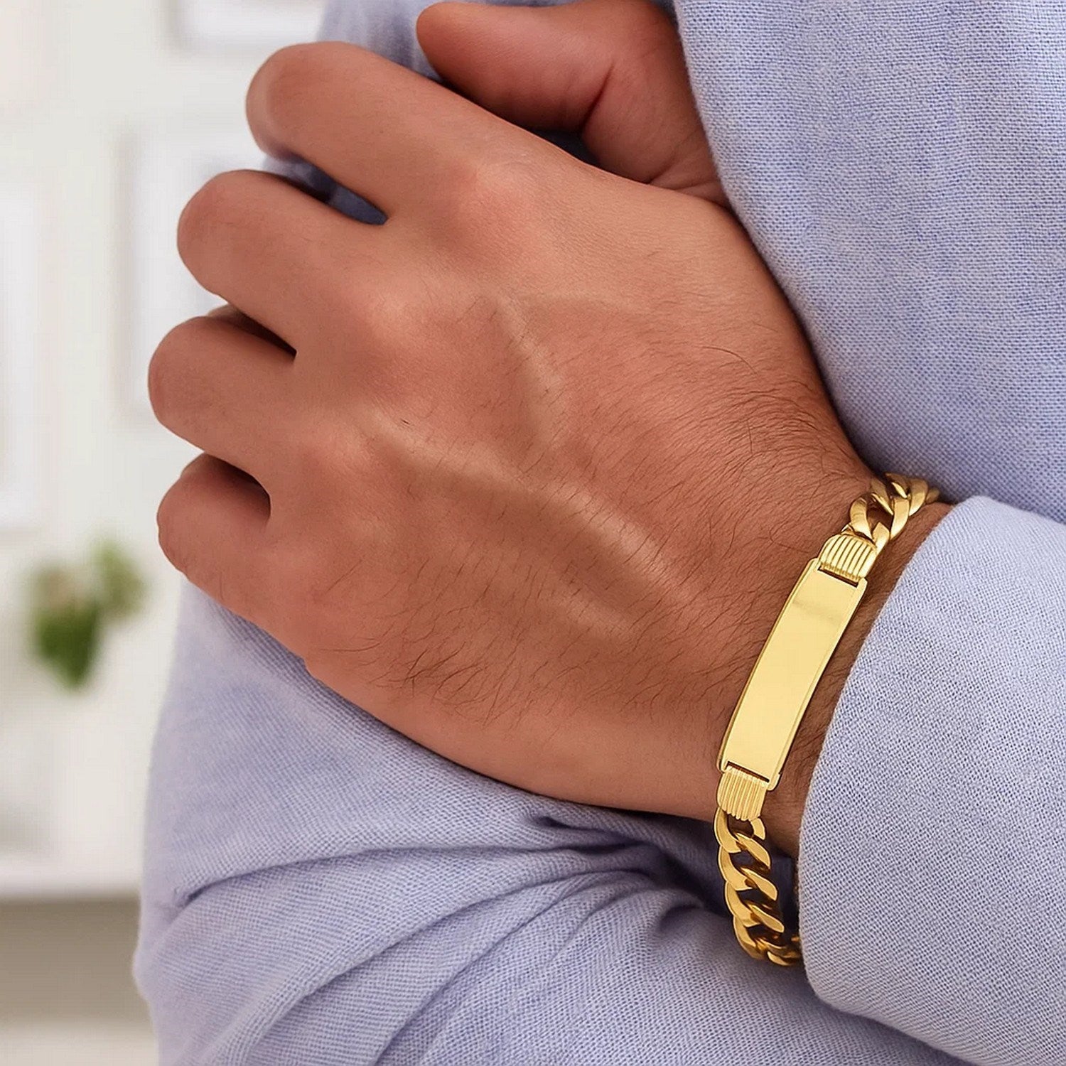 14k yellow gold curb ID bracelet with a polished rectangular plate on a man's wrist.