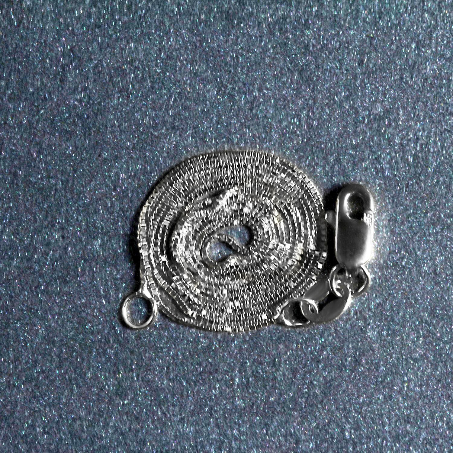 A coiled 10k white gold box chain with a lobster clasp on a glittery blue surface.