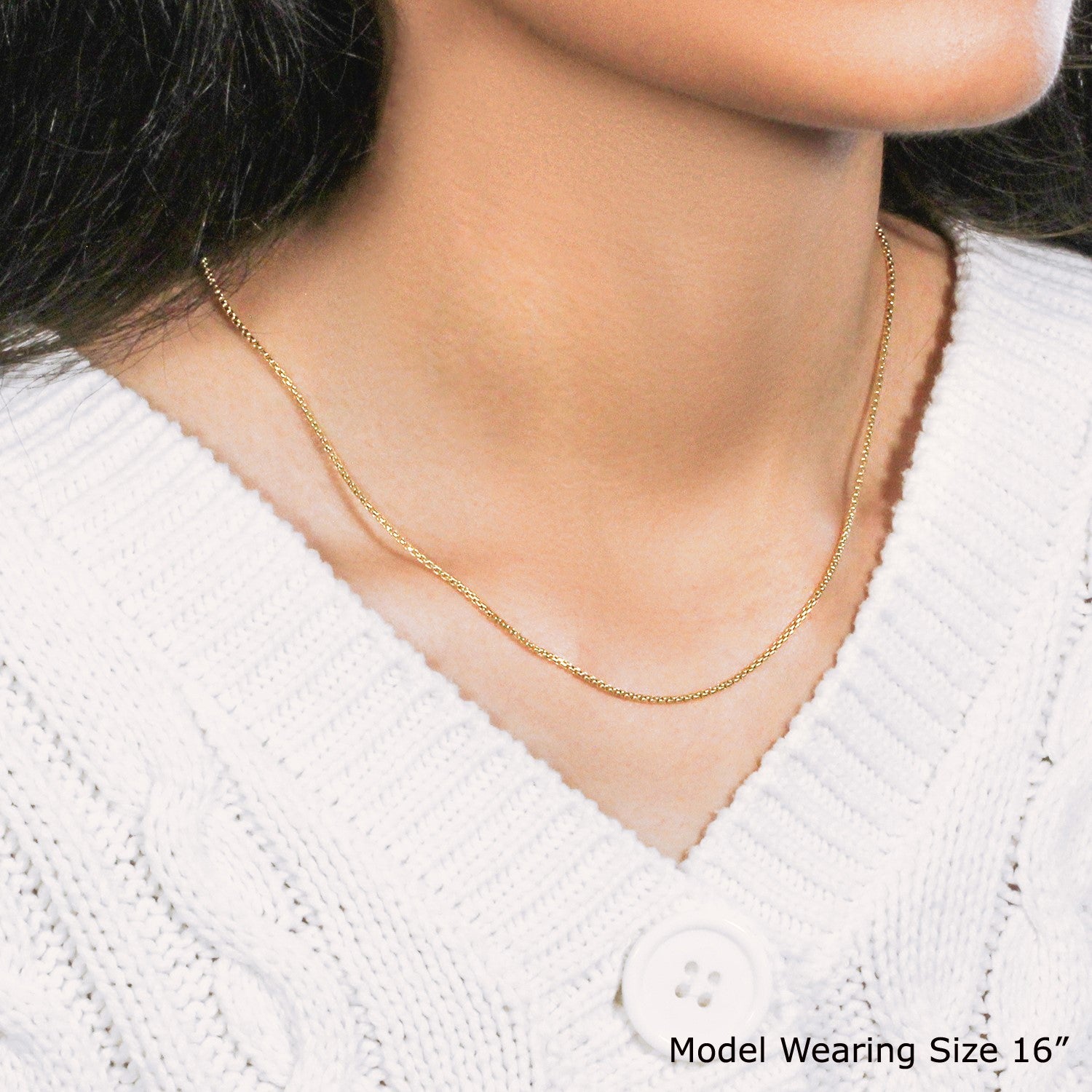 A 14k yellow gold round box chain (1.3 mm) worn by a model.