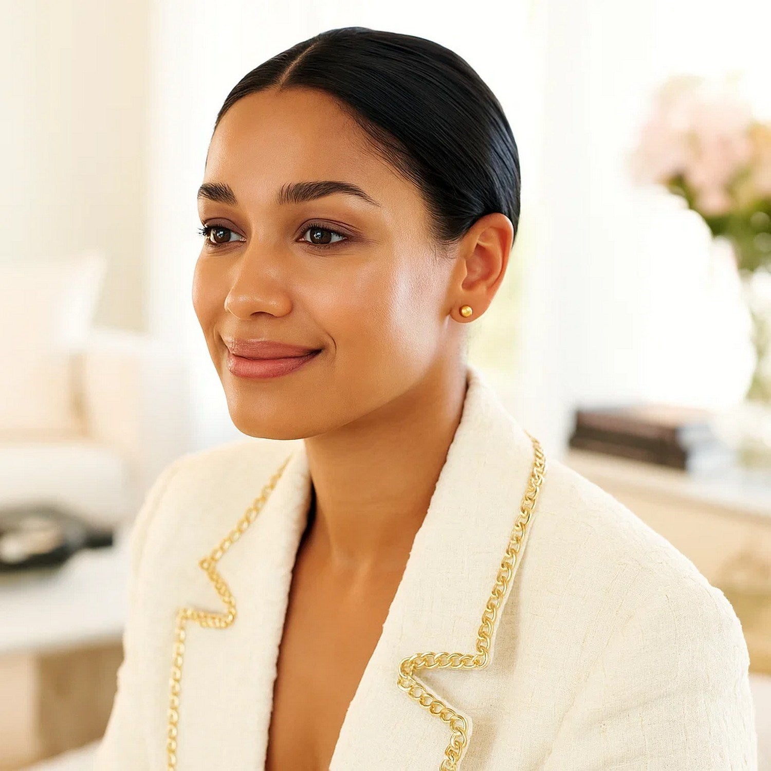 10k yellow gold round stud earrings on a woman with dark hair and a white jacket.