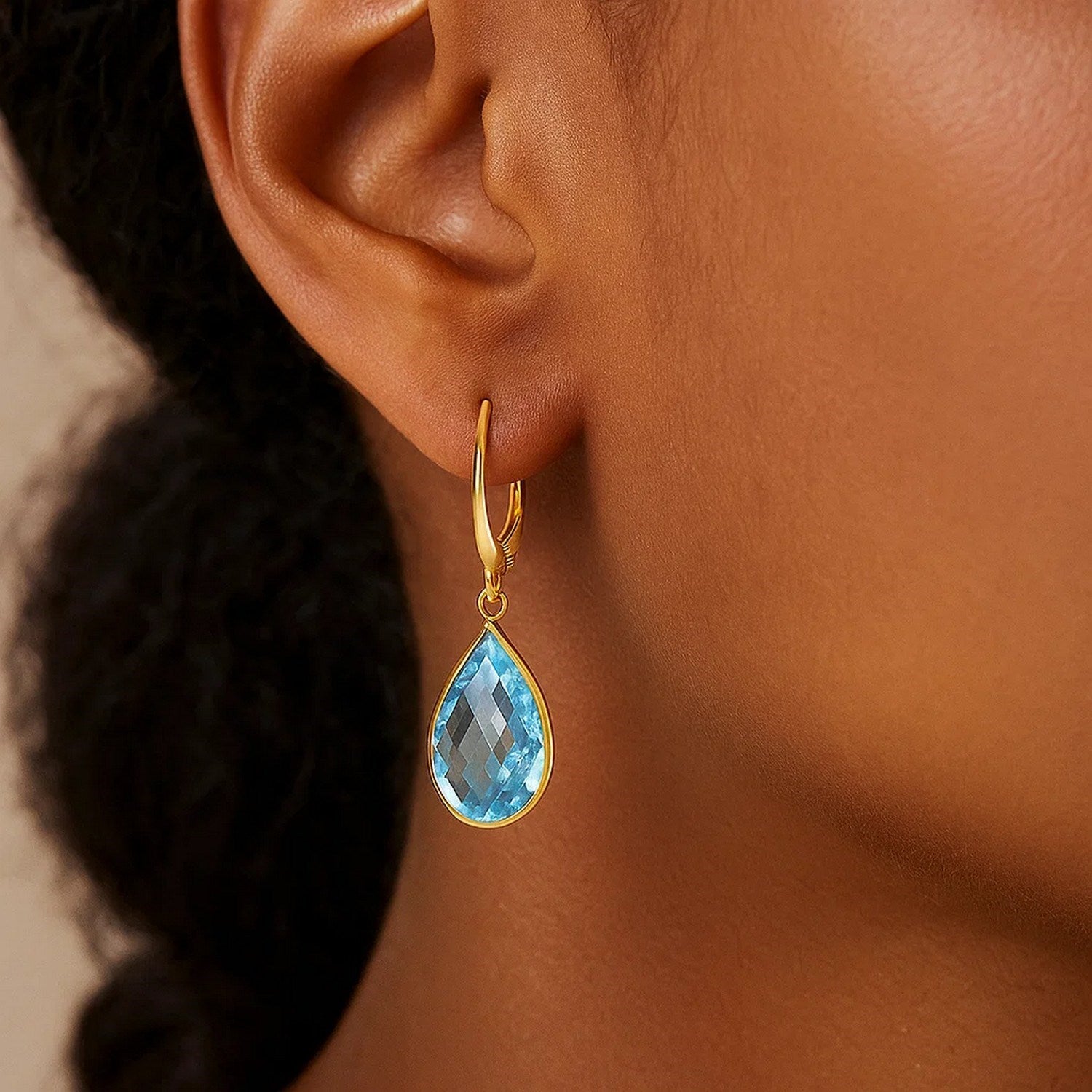 14k yellow gold drop earring with a pear-shaped blue topaz briolette.