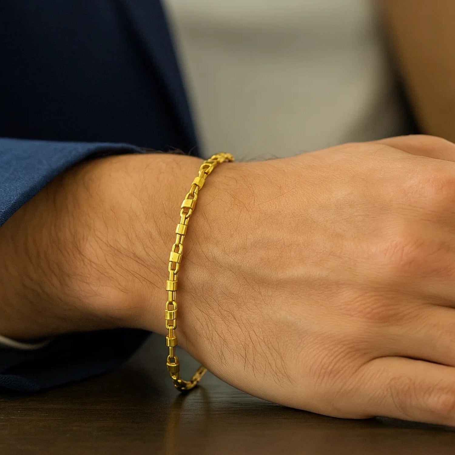 A 14K yellow gold square Byzantine chain bracelet on a person's wrist.