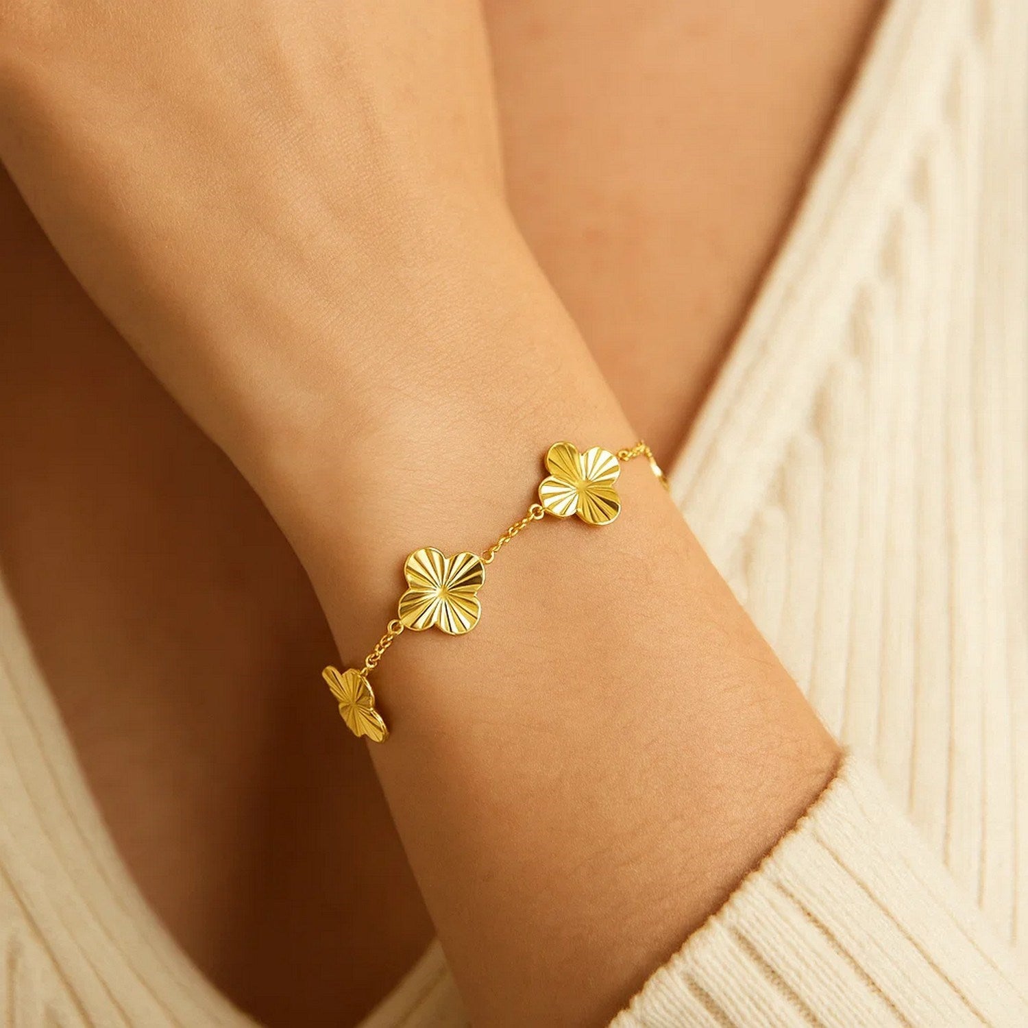 14K yellow gold clover bracelet on a person's wrist.