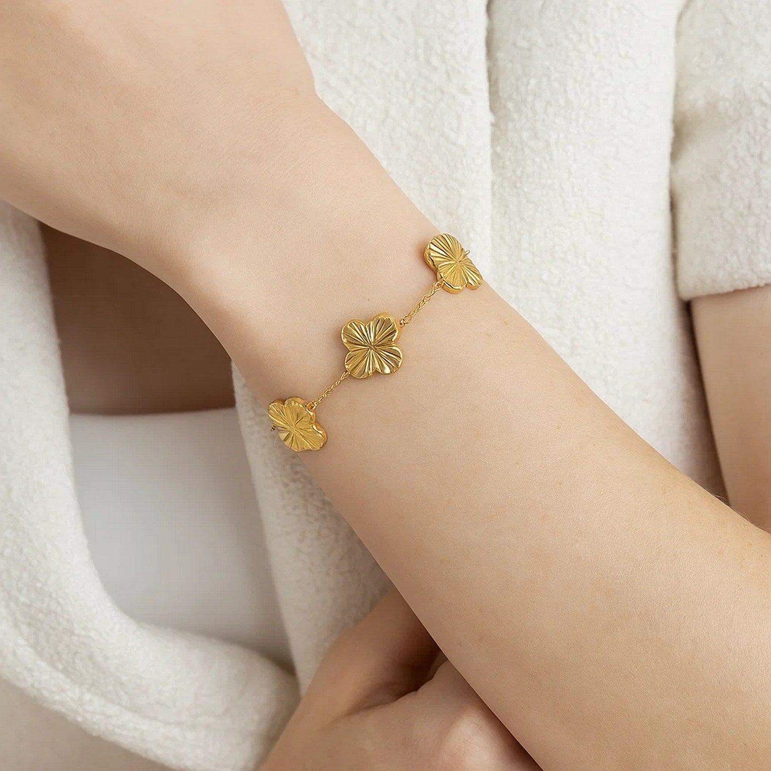 A 14K yellow gold clover bracelet with three textured clover links on a delicate chain.