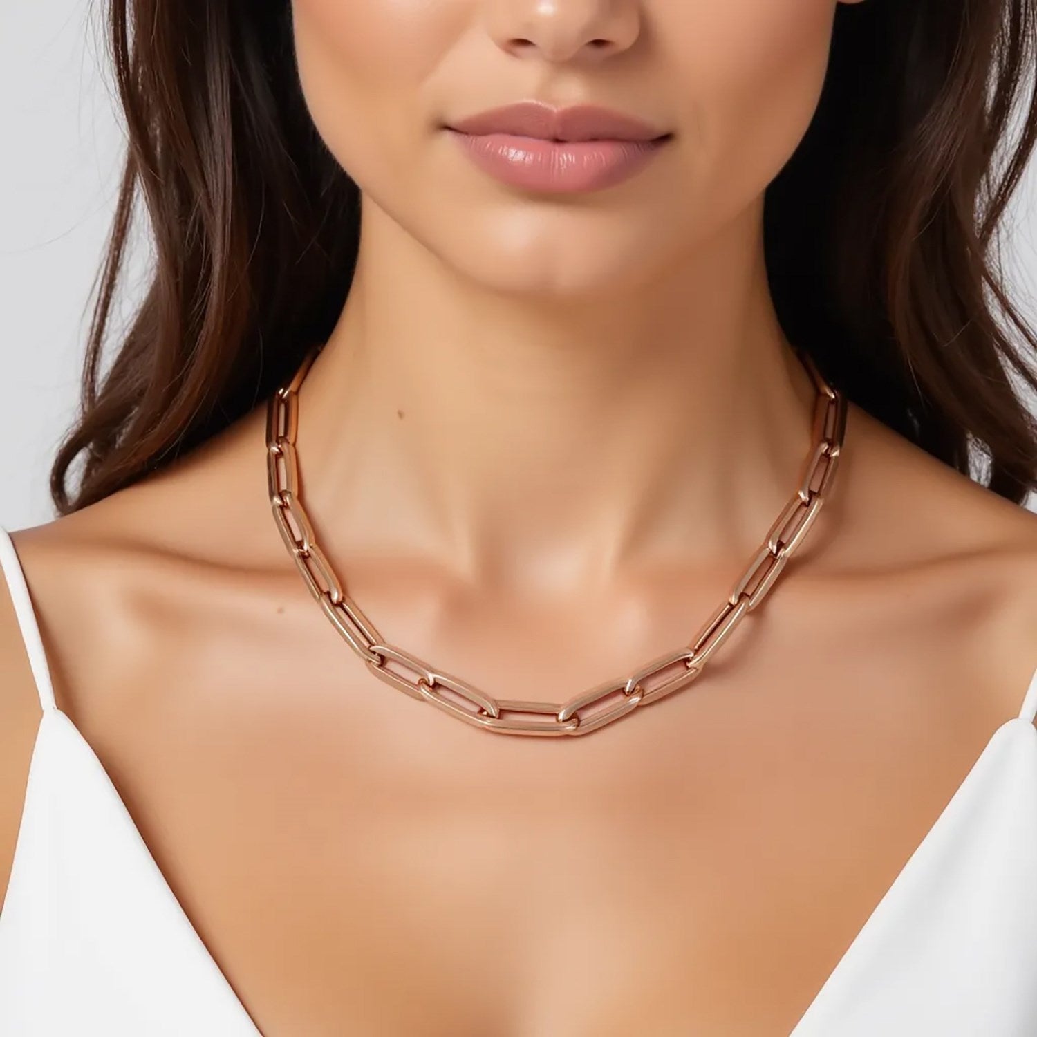 14K rose gold wide paperclip chain with 6.10 mm links on a woman's neck.