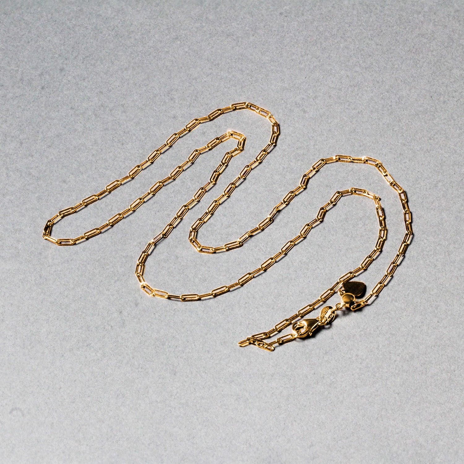 14k yellow gold adjustable paperclip chain with a heart dangle and lobster clasp.
