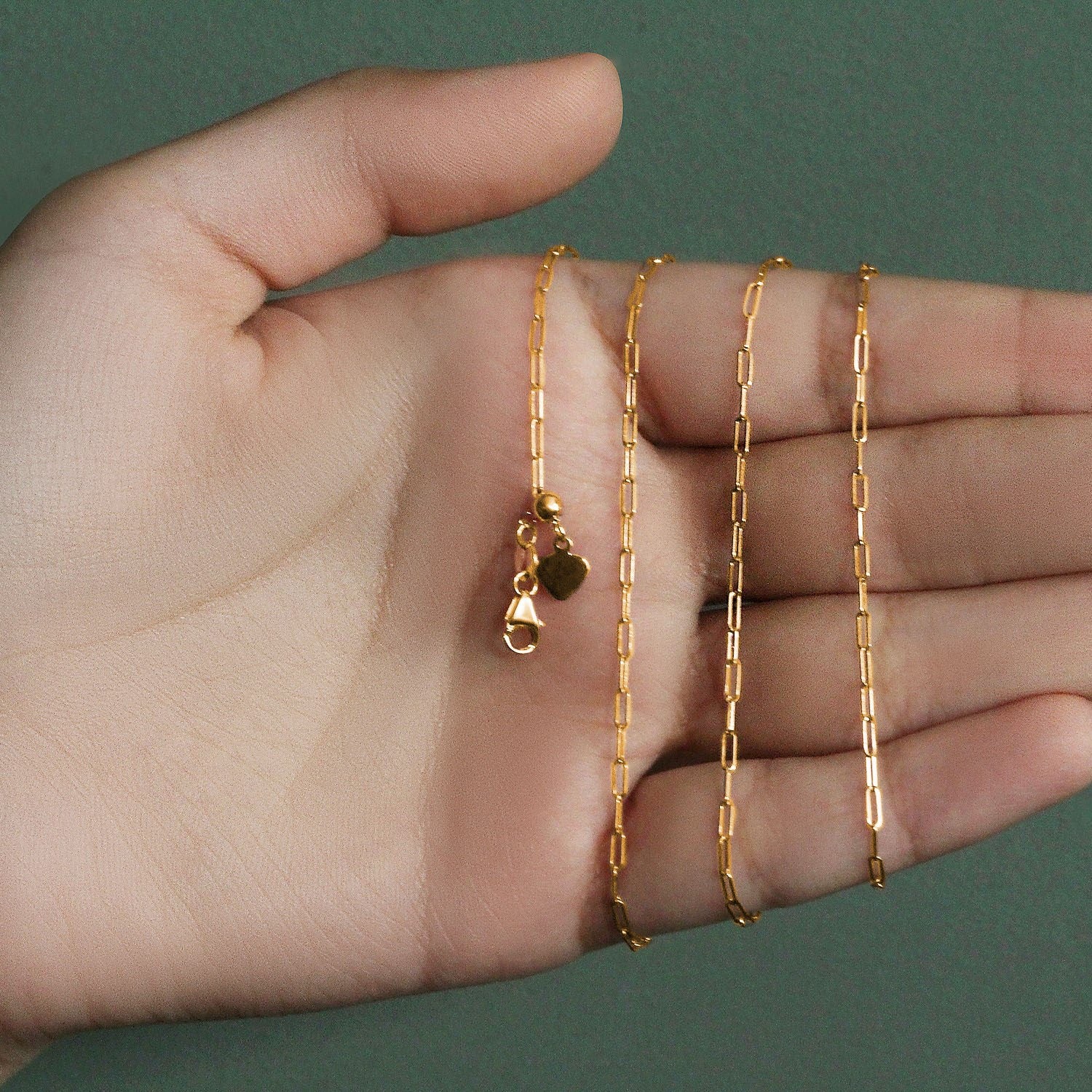 14k yellow gold adjustable paperclip chain with a heart dangle and lobster clasp.