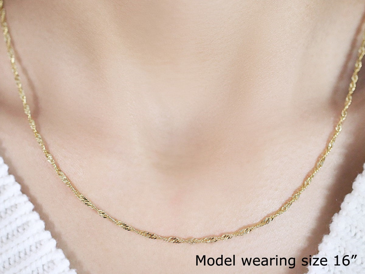 A 14k yellow gold Singapore chain, 1.80 mm wide, worn by a model.