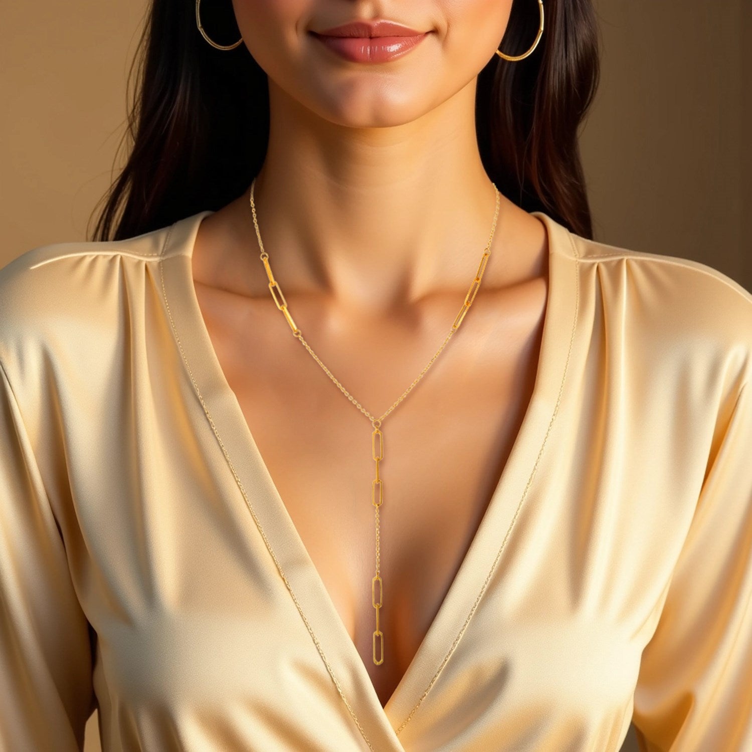 14K yellow gold lariat necklace with paperclip chain stations on a woman.