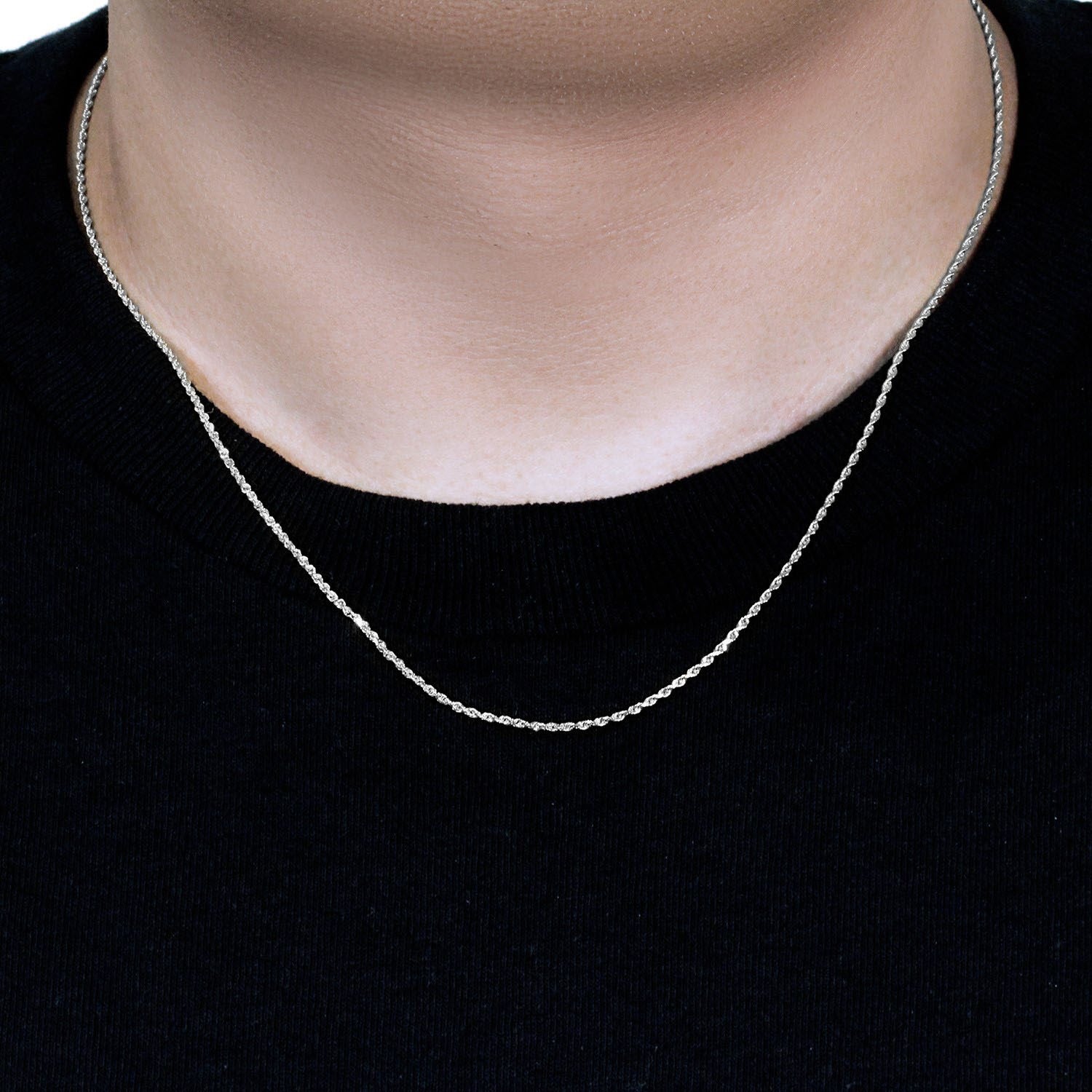 A 10k white gold solid diamond cut rope chain on a person's neck.