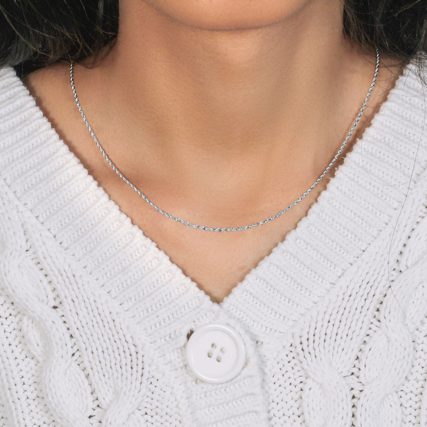 A 10k white gold solid diamond cut rope chain is worn around a person's neck.