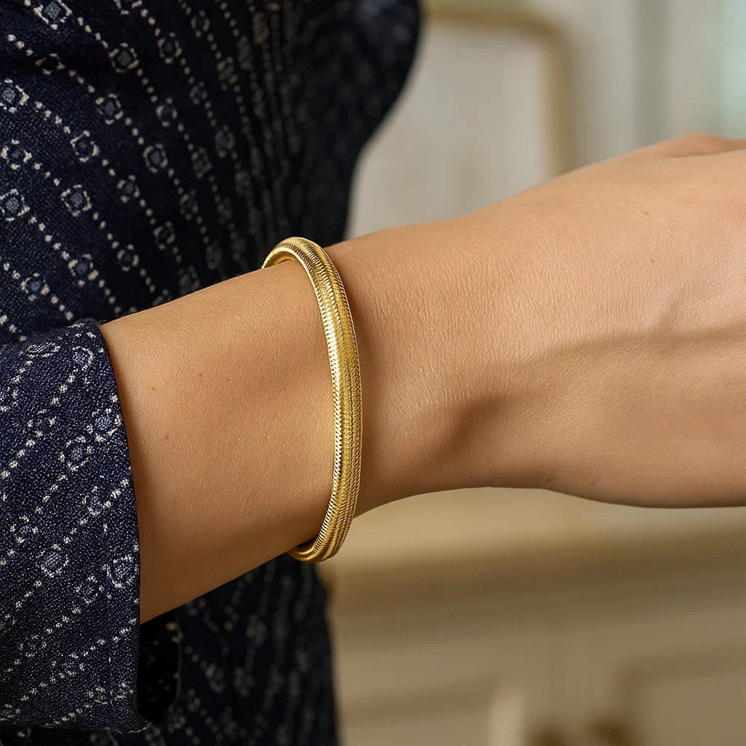 14K yellow gold medium stretch mesh bracelet on a person's wrist.