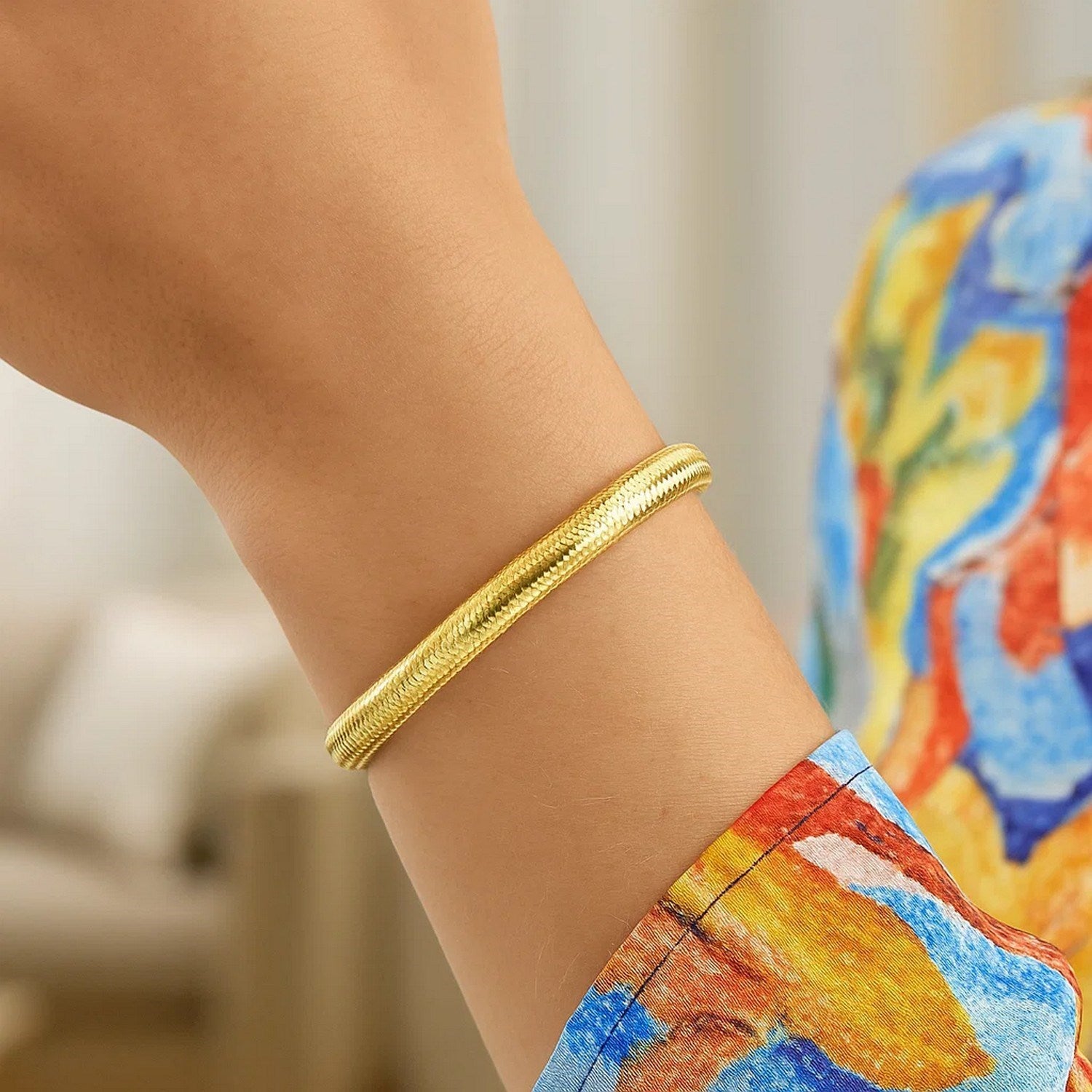 14K yellow gold medium stretch mesh bracelet on a person's wrist.