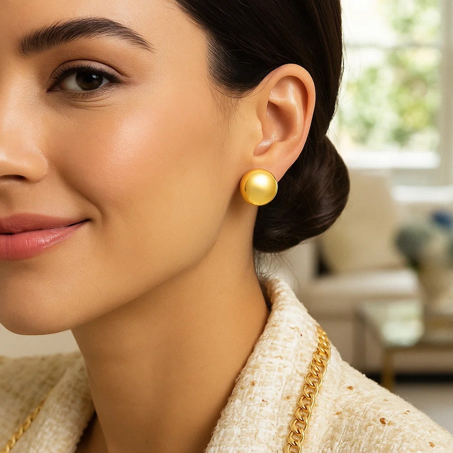 14K yellow gold puffed button stud earrings on a woman.