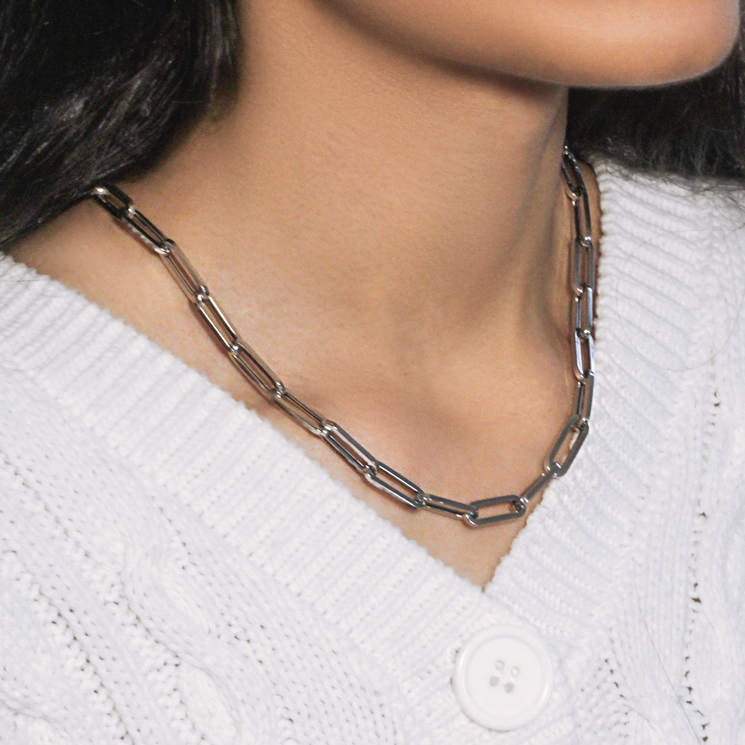 14K white gold wide paperclip chain on a person wearing a white sweater.