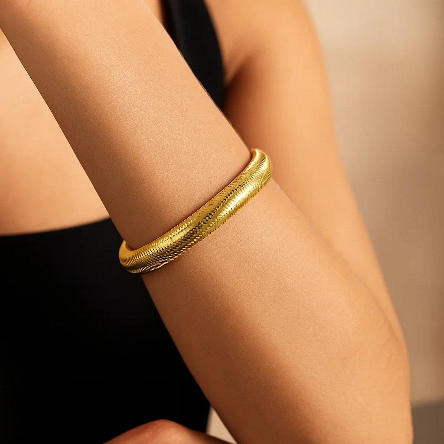 14K yellow gold large stretch mesh bracelet on a person's arm.