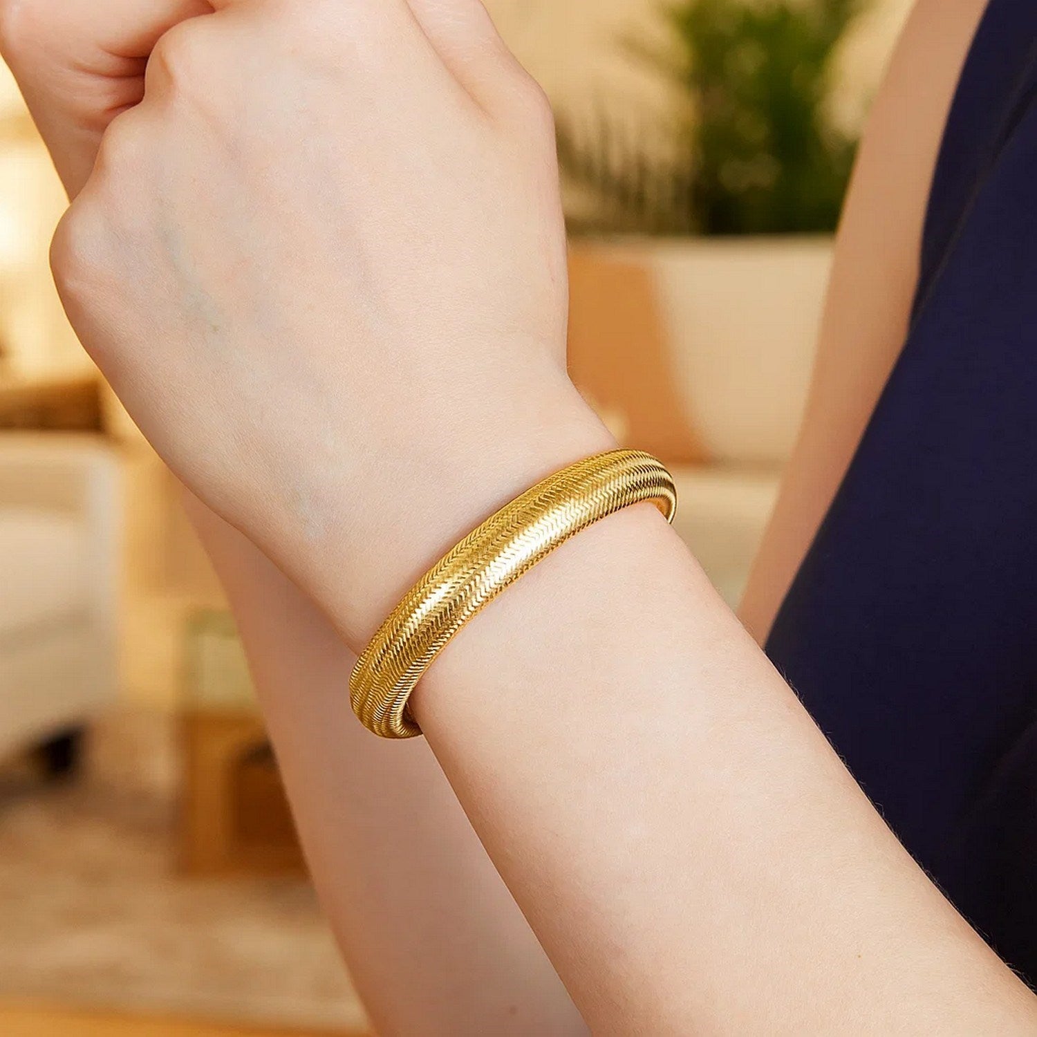 14K yellow gold large stretch mesh bracelet on a person's wrist.